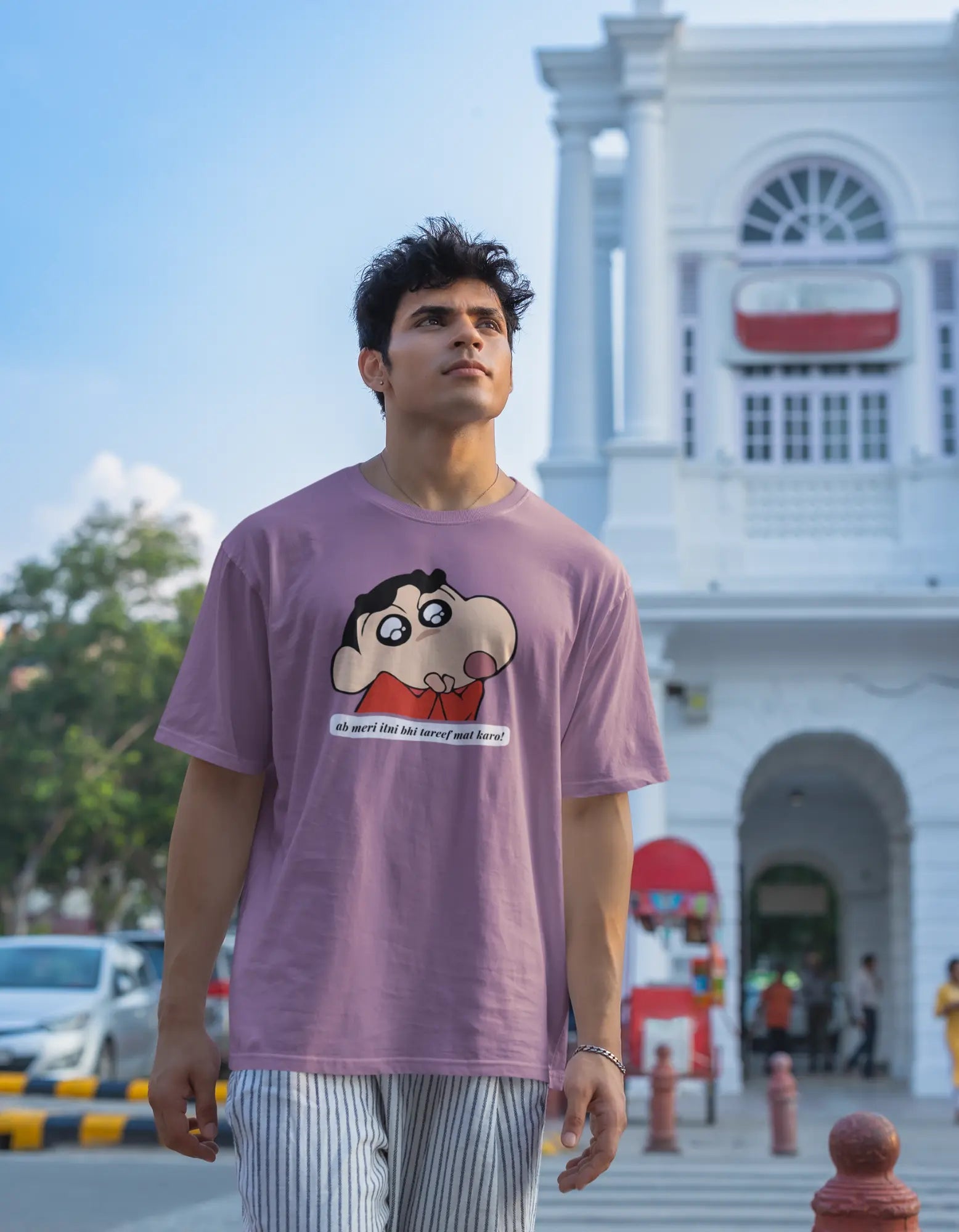 Second front view of male model wearing an oversized dirty purple tee featuring Shinchan with the text "Don't Praise Me So Much" in Hindi. A perfect blend of humor and nostalgia for Shinchan fans.