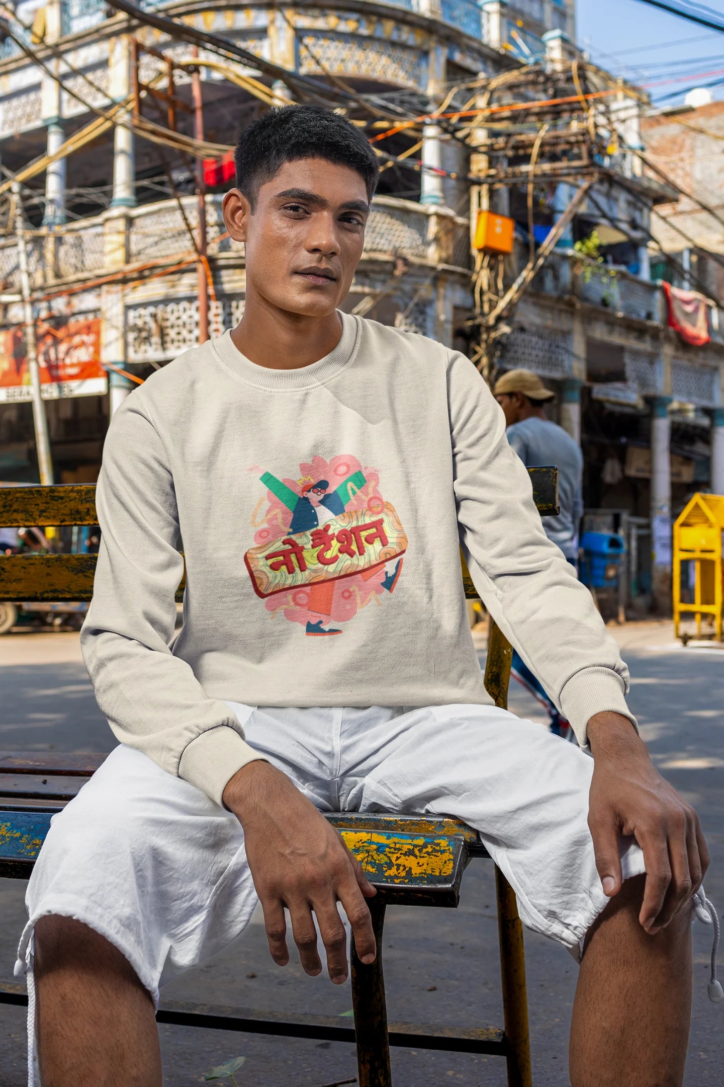 4th front view of a male model wearing a cream oversized t-shirt with the phrase "No Tension" in a relaxed, unique script.