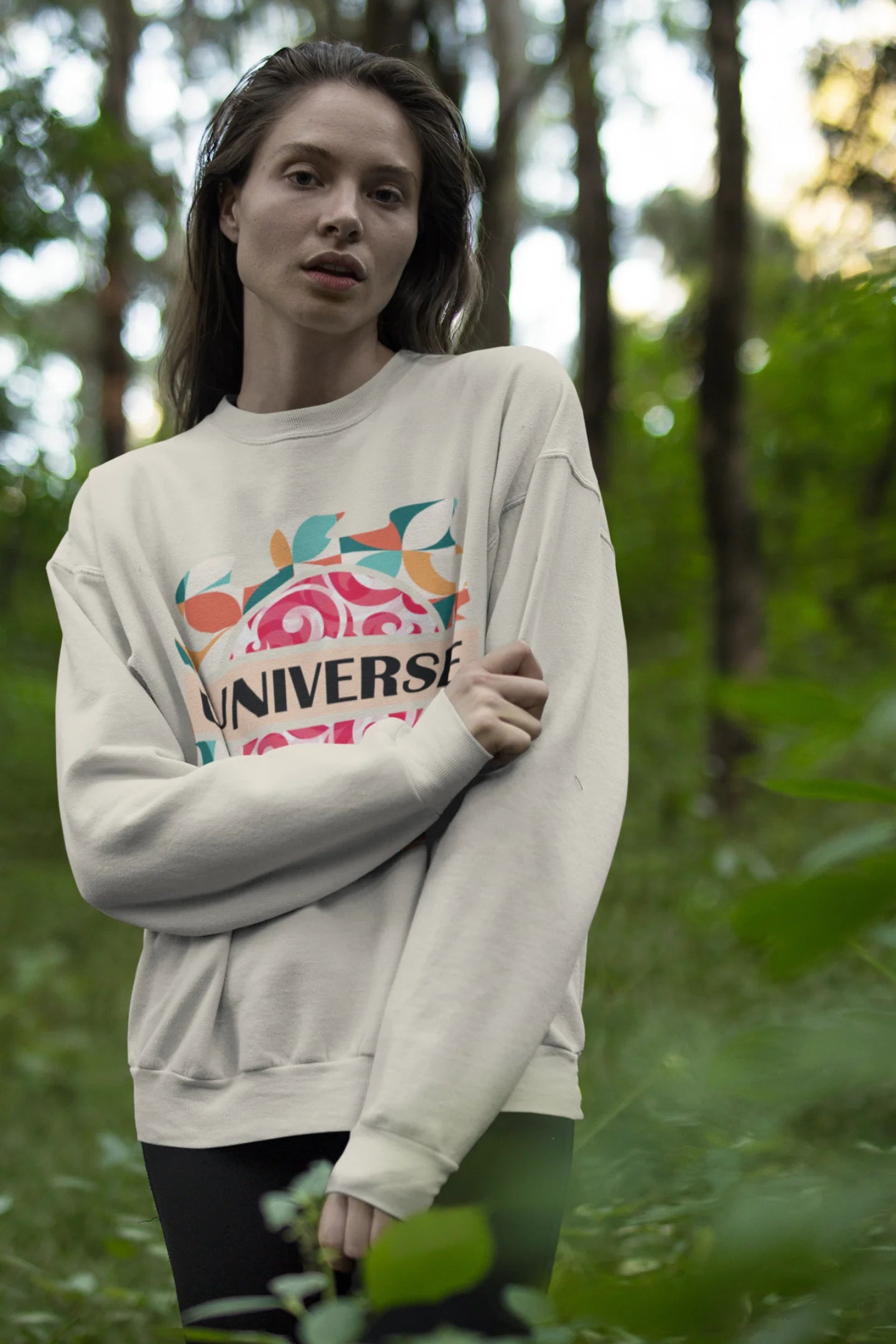 Fourth front view of a female model wearing an cream sweatshirt with a cosmic Universe design inspired by Coldplay.