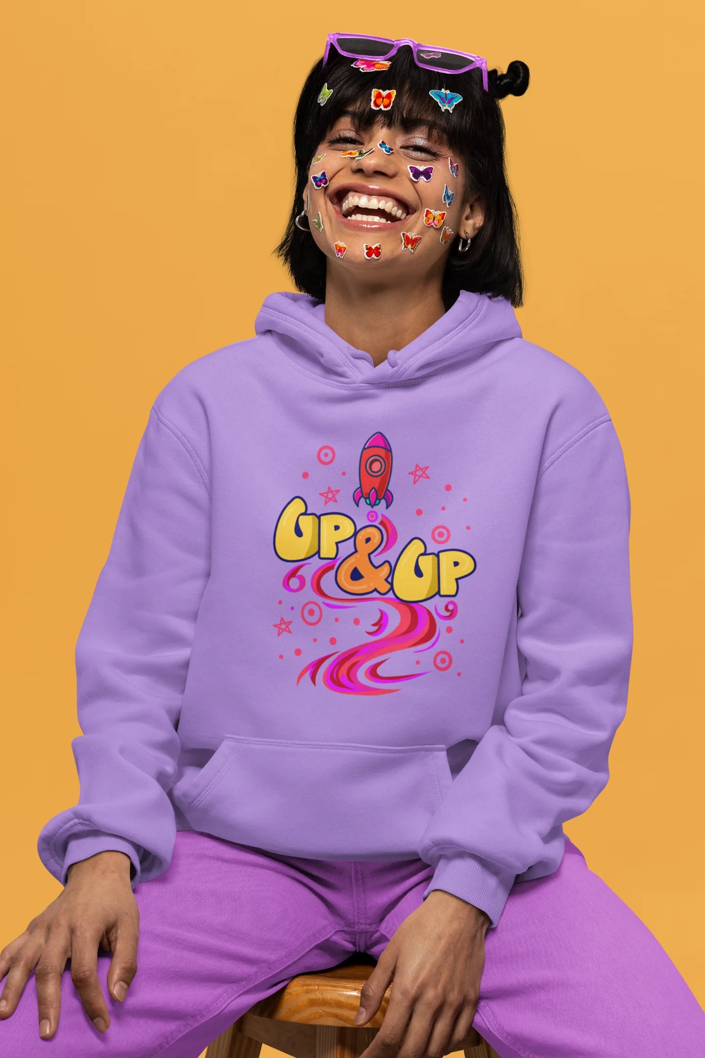 Second front view of a female model wearing an lavender hoodie with a rocket ship design and the text "Up & Up".