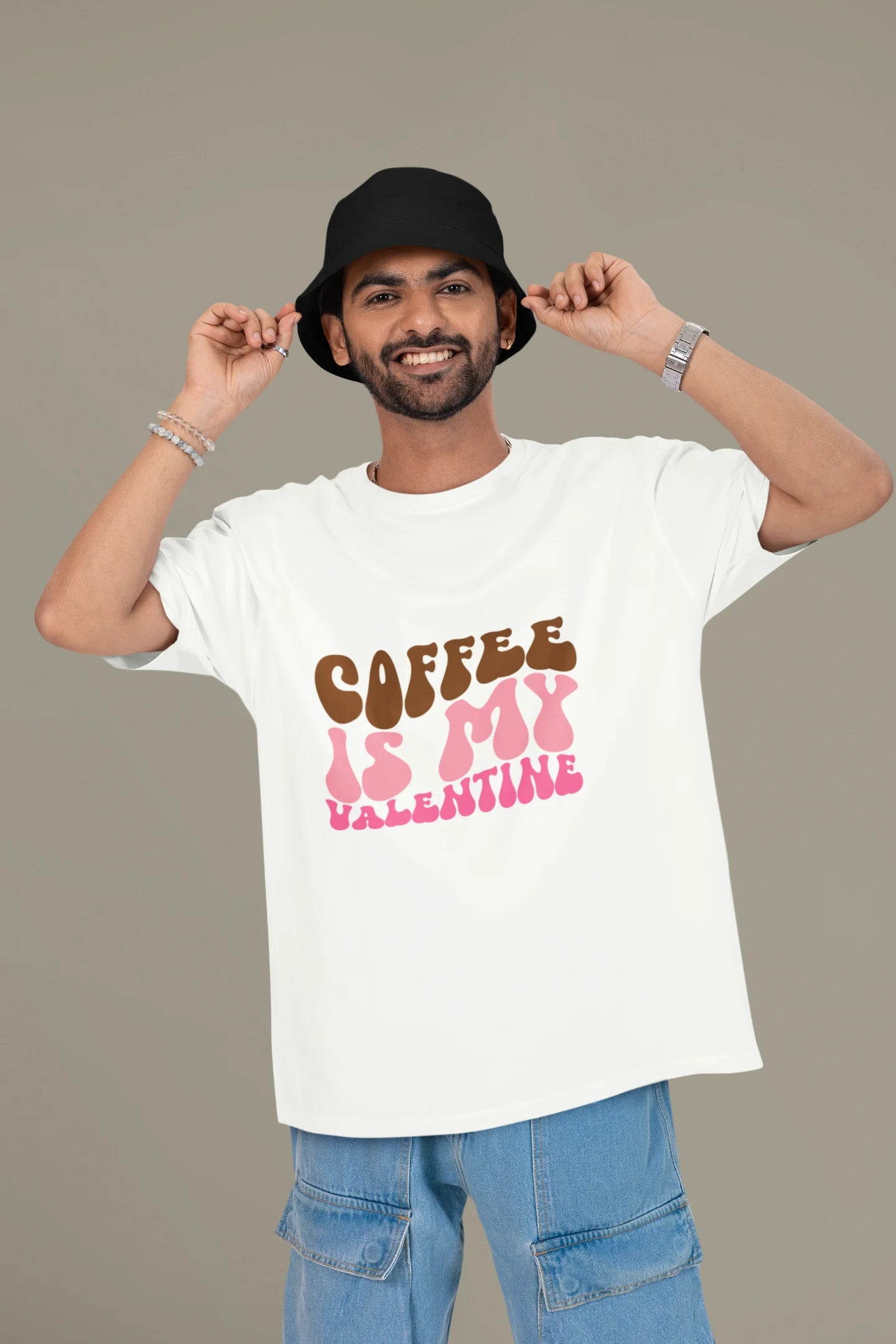 3rd front view of a male model wearing a white oversized t-shirt with the text "Coffee is My Valentine" printed on it.