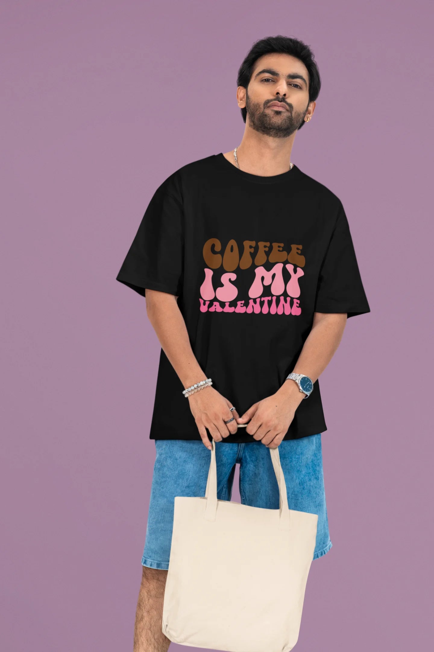 First front view of a male model wearing a black oversized t-shirt with the text "Coffee is My Valentine" printed on it.