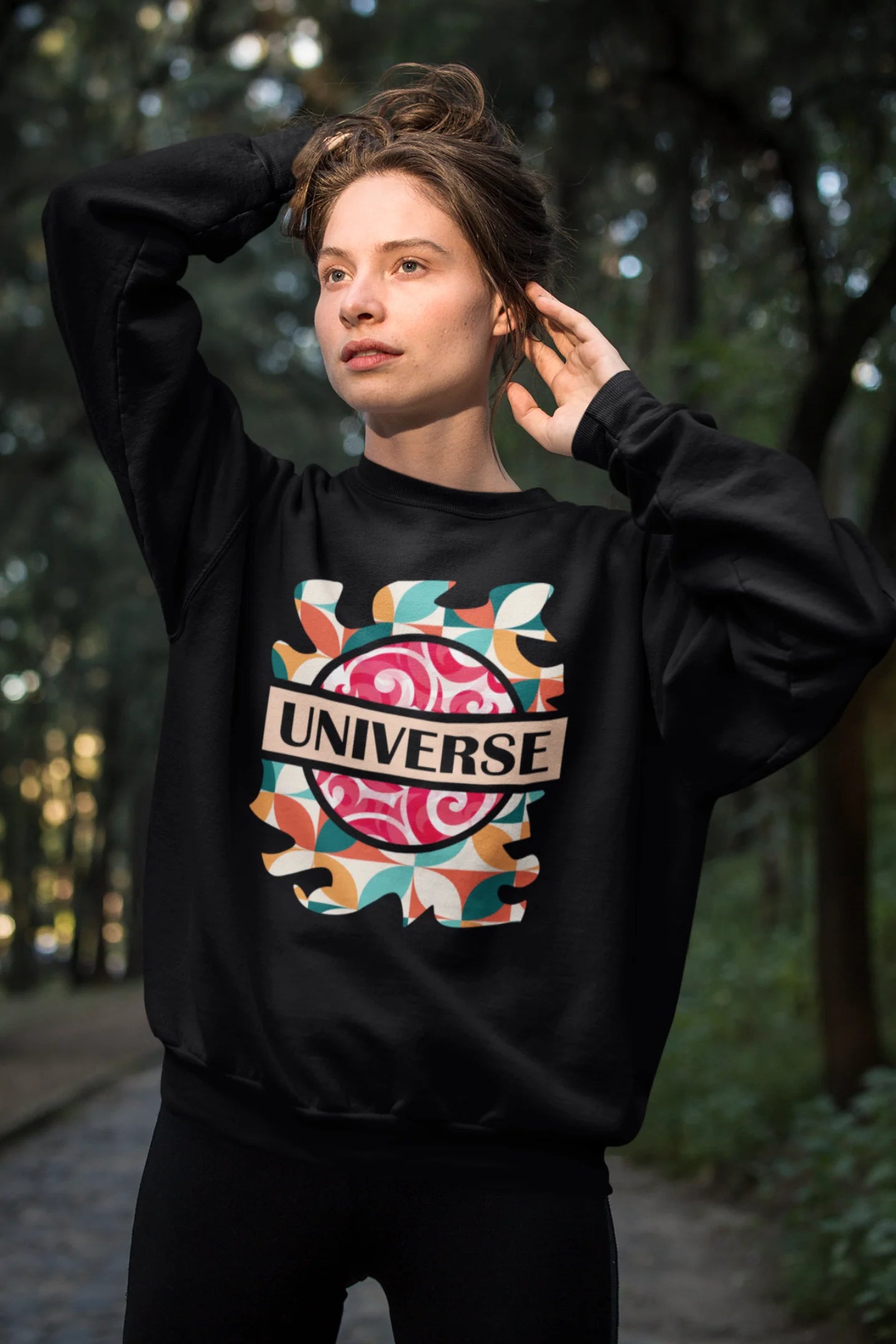 First front view of a female model wearing an black sweatshirt with a cosmic Universe design inspired by Coldplay.