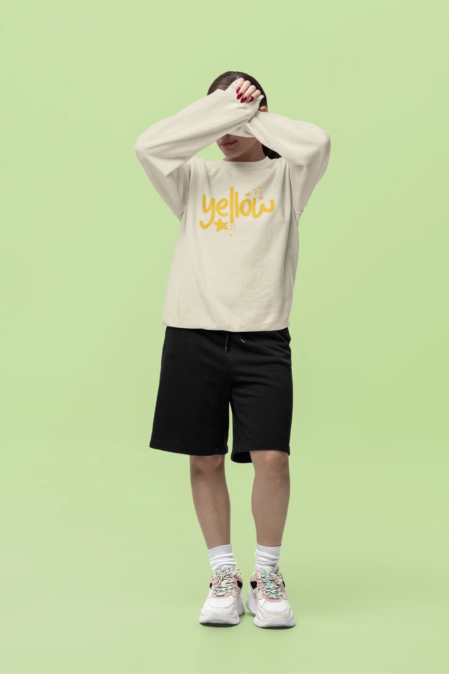 Fourth front view of a female model wearing a cream sweatshirt with the "Yellow" album artwork by Coldplay.