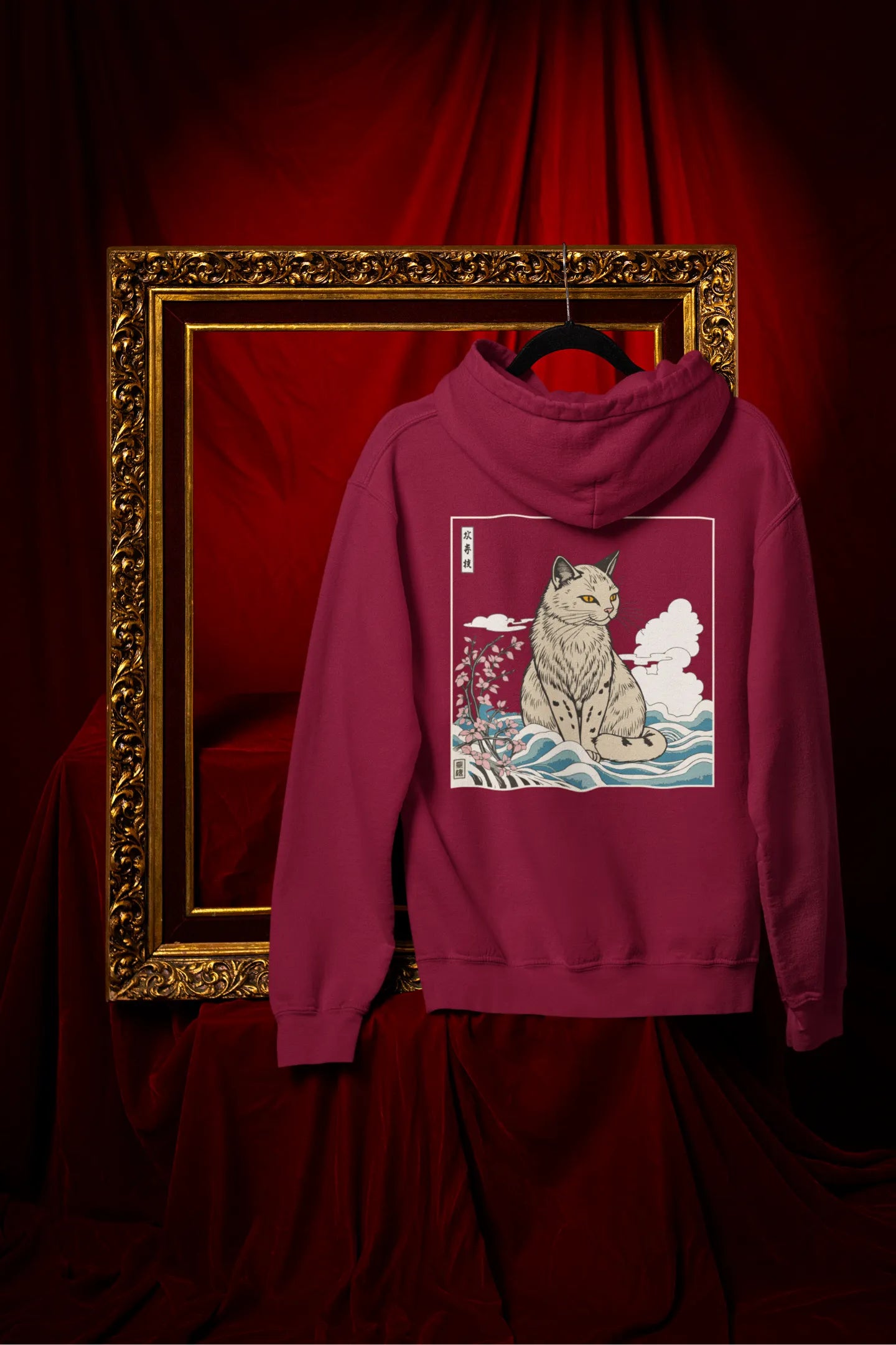 Back view of a maroon hoodie with a design of a wildcat sitting on ocean waves.