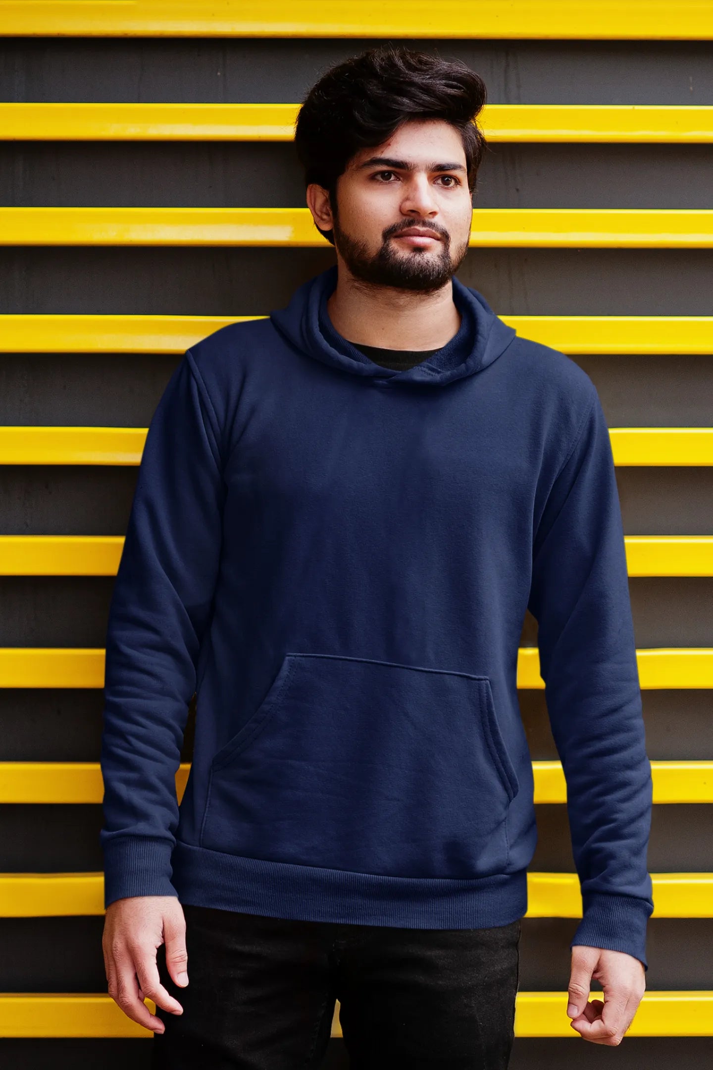 Third front view of a male model wearing a navy blue hoodie featuring a Range Rover Defender design, exuding power and ruggedness.