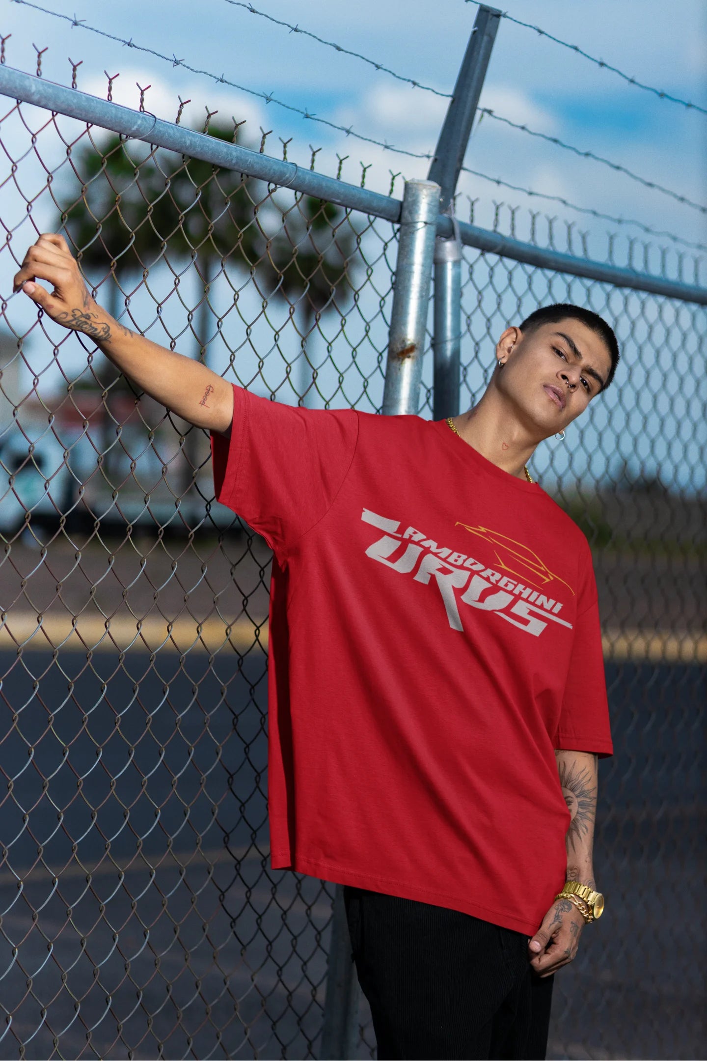 Another front view of a male model wearing a red oversized t-shirt featuring a design of a Lamborghini Urus.