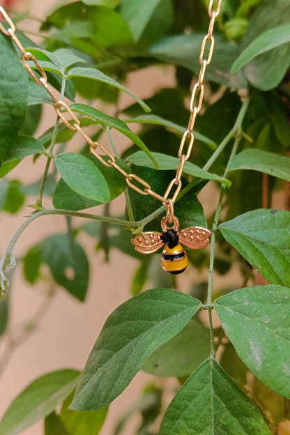 4th view of a gold chain necklace with a small pendant shaped like a honey bee.