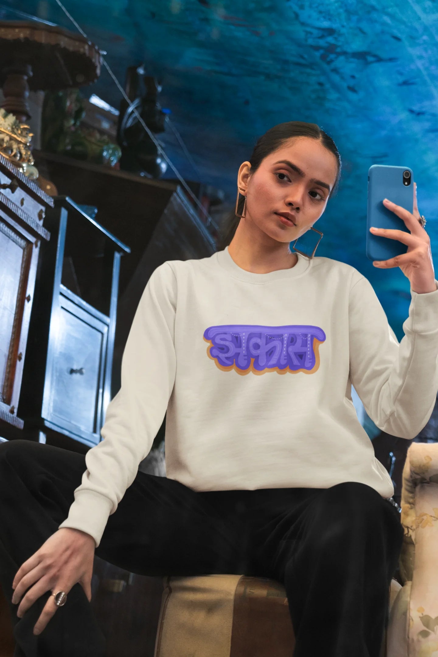 5th front view of a female model wearing an cream sweatshirt featuring "Jhakas" in a stylish font.