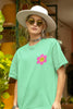 Close up view of a female model wearing an oversized mint green t-shirt with a positive message 