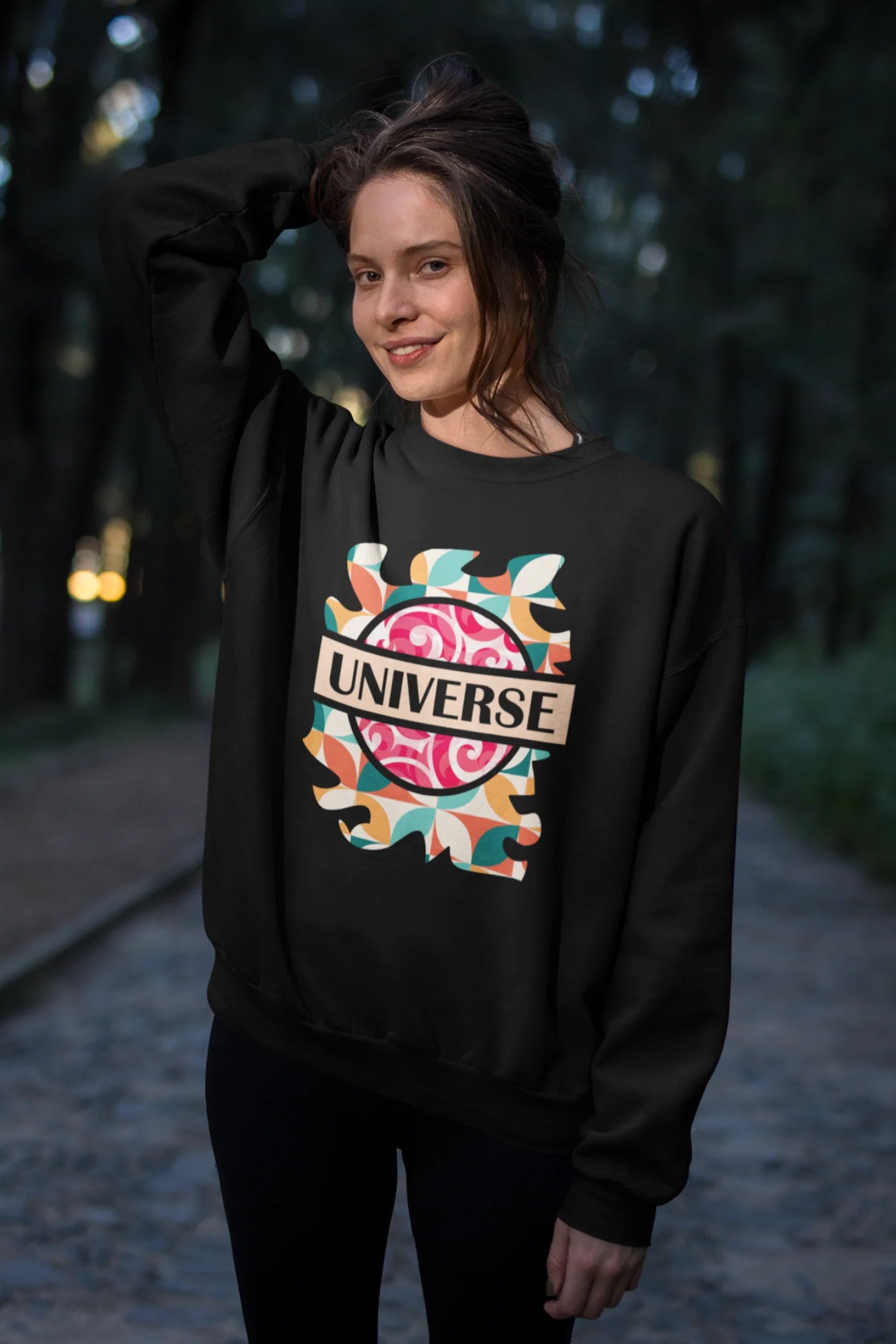 Third front view of a female model wearing an black sweatshirt with a cosmic Universe design inspired by Coldplay.