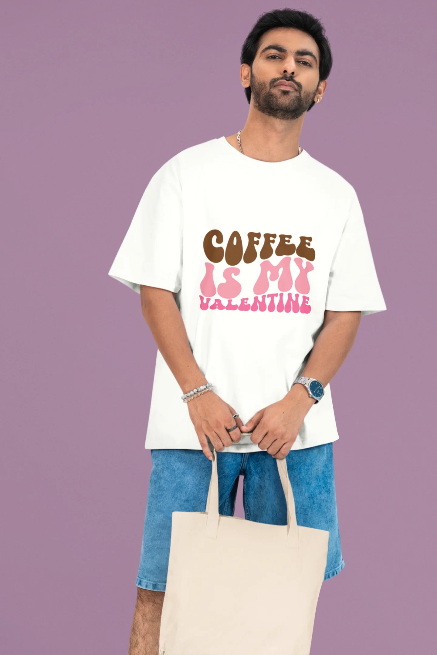 First front view of a male model wearing a white oversized t-shirt with the text "Coffee is My Valentine" printed on it.