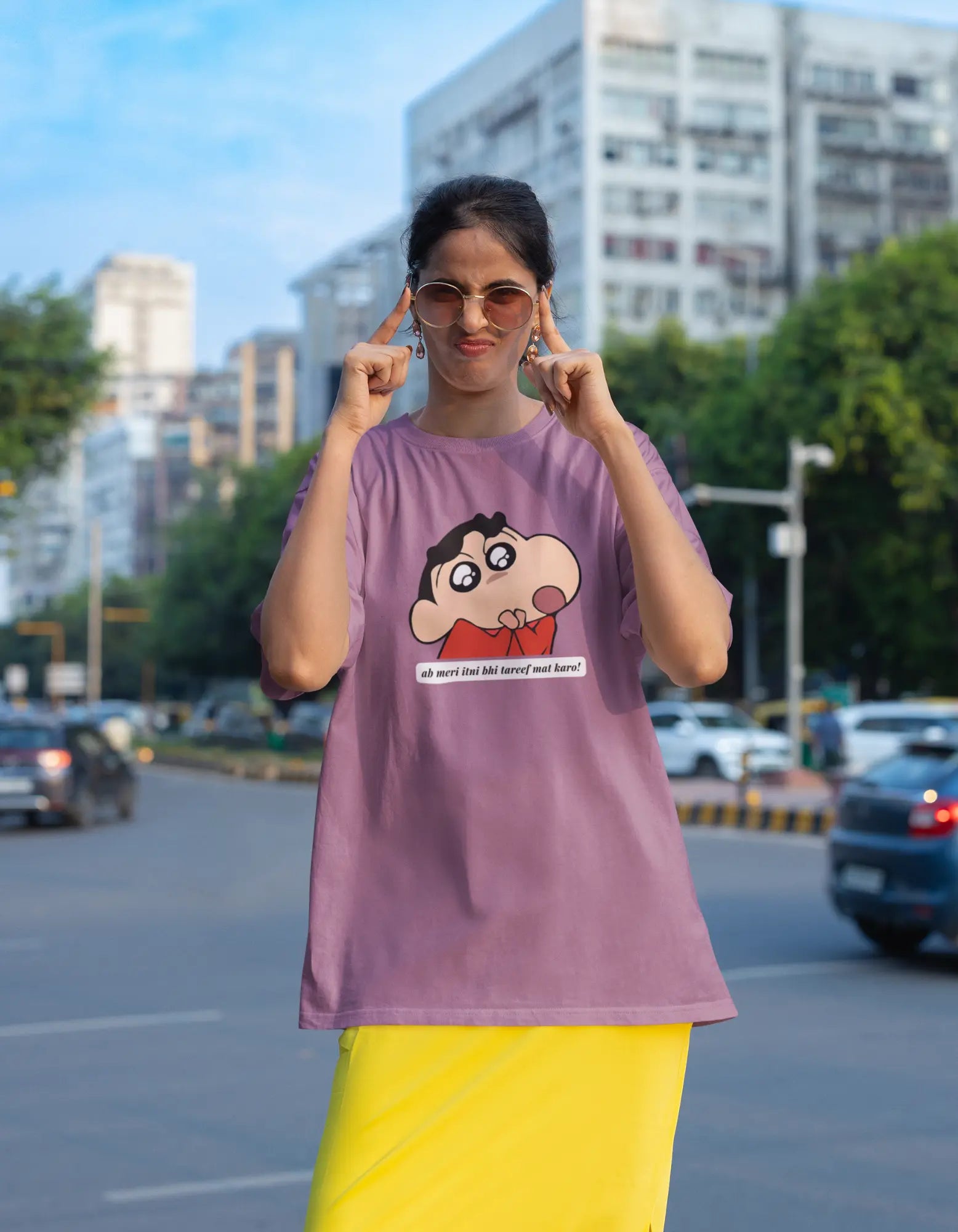 Third front view of female model wearing an oversized dirty purple tee featuring Shinchan with the text "Don't Praise Me So Much" in Hindi. A perfect blend of humor and nostalgia for Shinchan fans.