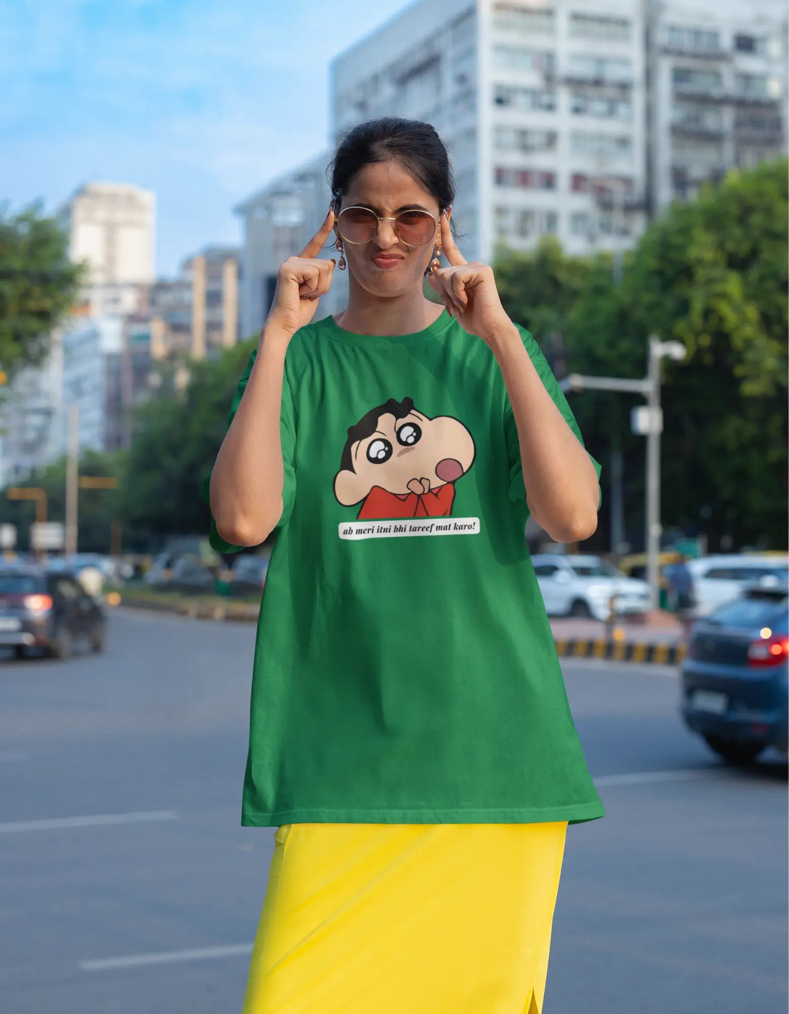 Fourth front view of female model wearing an oversized forest green tee featuring Shinchan with the text "Don't Praise Me So Much" in Hindi. A perfect blend of humor and nostalgia for Shinchan fans.