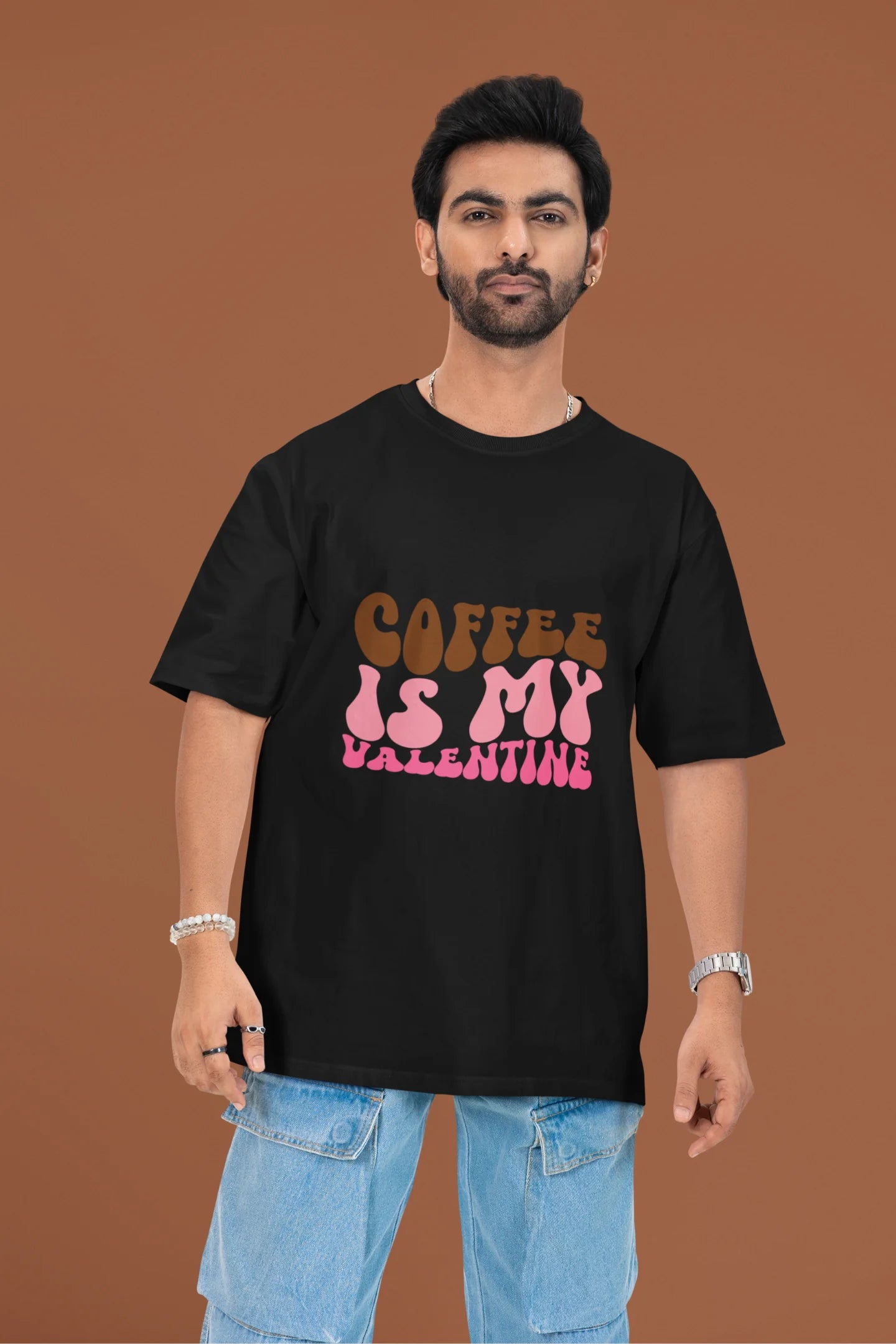 3rd front view of a male model wearing a black oversized t-shirt with the text "Coffee is My Valentine" printed on it.