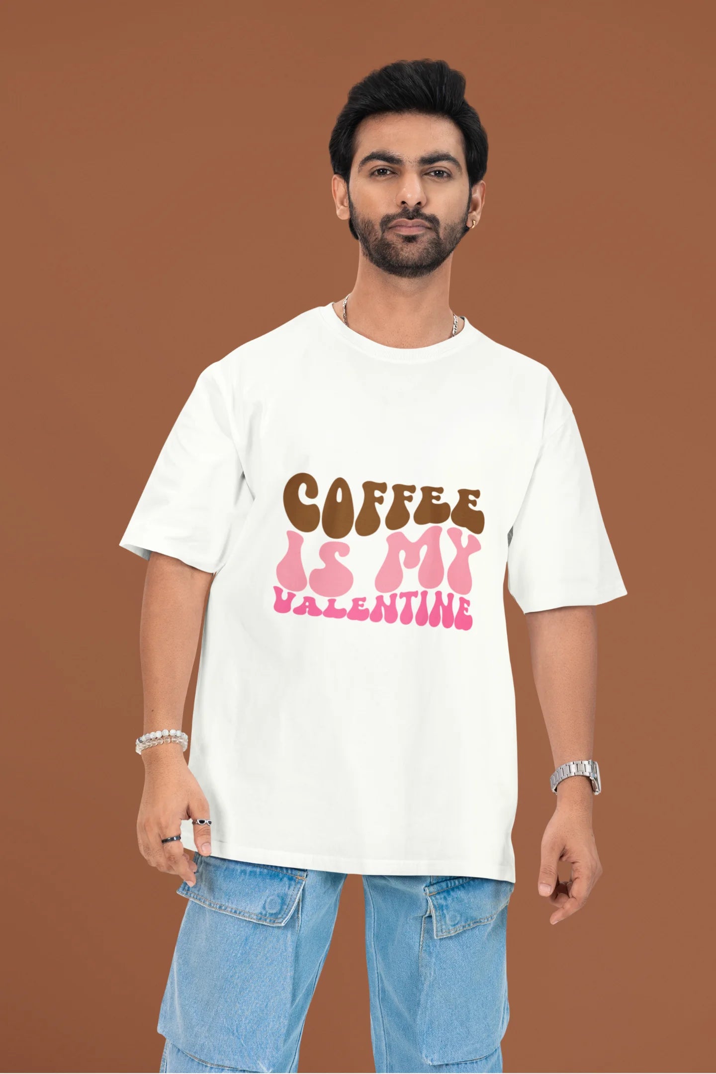 2nd front view of a male model wearing a white oversized t-shirt with the text "Coffee is My Valentine" printed on it.