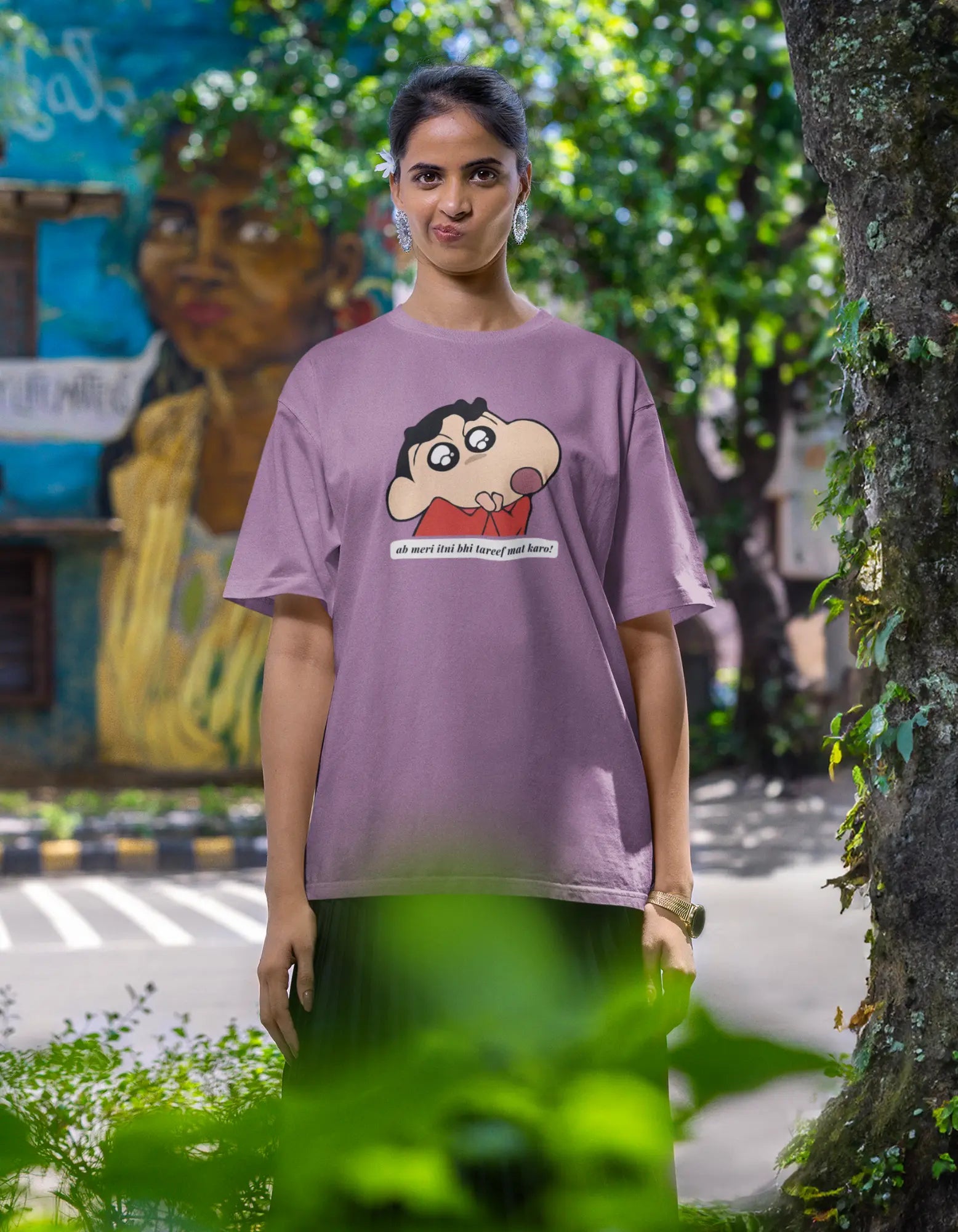 Fourth front view of female model wearing an oversized dirty purple tee featuring Shinchan with the text "Don't Praise Me So Much" in Hindi. A perfect blend of humor and nostalgia for Shinchan fans.