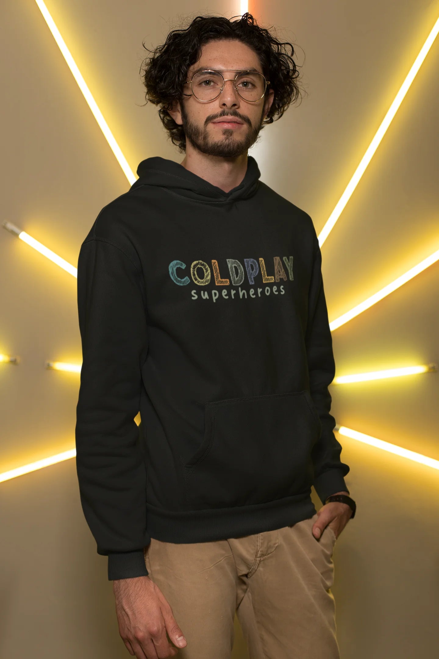 3rd front view of a male model wearing an black hoodie with a design inspired by the "Something Just Like This" music video, featuring the word "Superheroes".