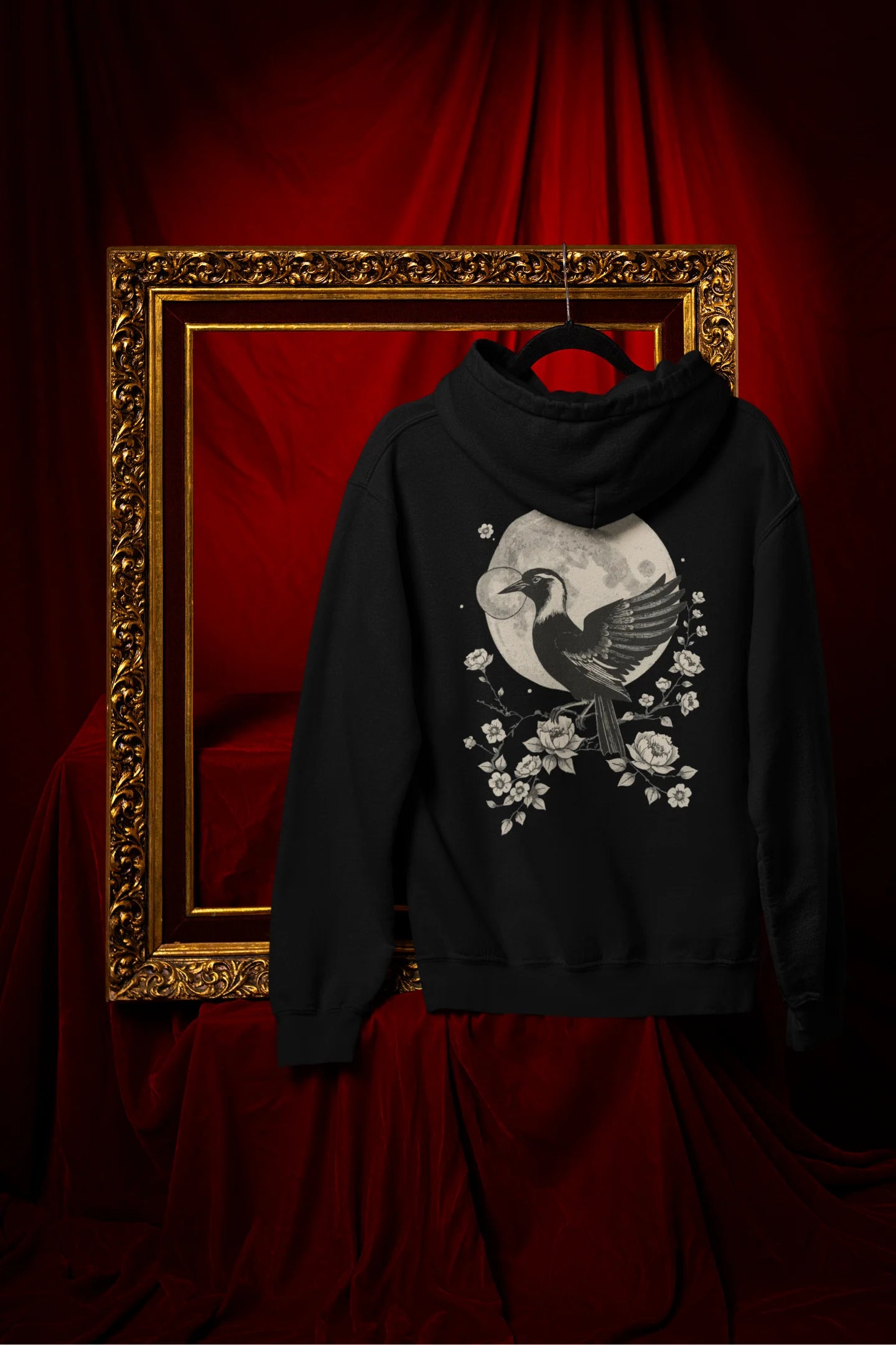 Back view of a black hoodie with a heron taking off under the moonlight.