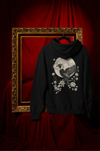 Back view of a black hoodie with a heron taking off under the moonlight.