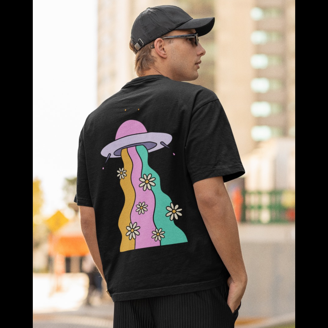 Back view of a male model wearing a black oversized t-shirt featuring a fun "Space Wreck" design with elements of spaceships, UFOs, and a hint of extraterrestrial life.