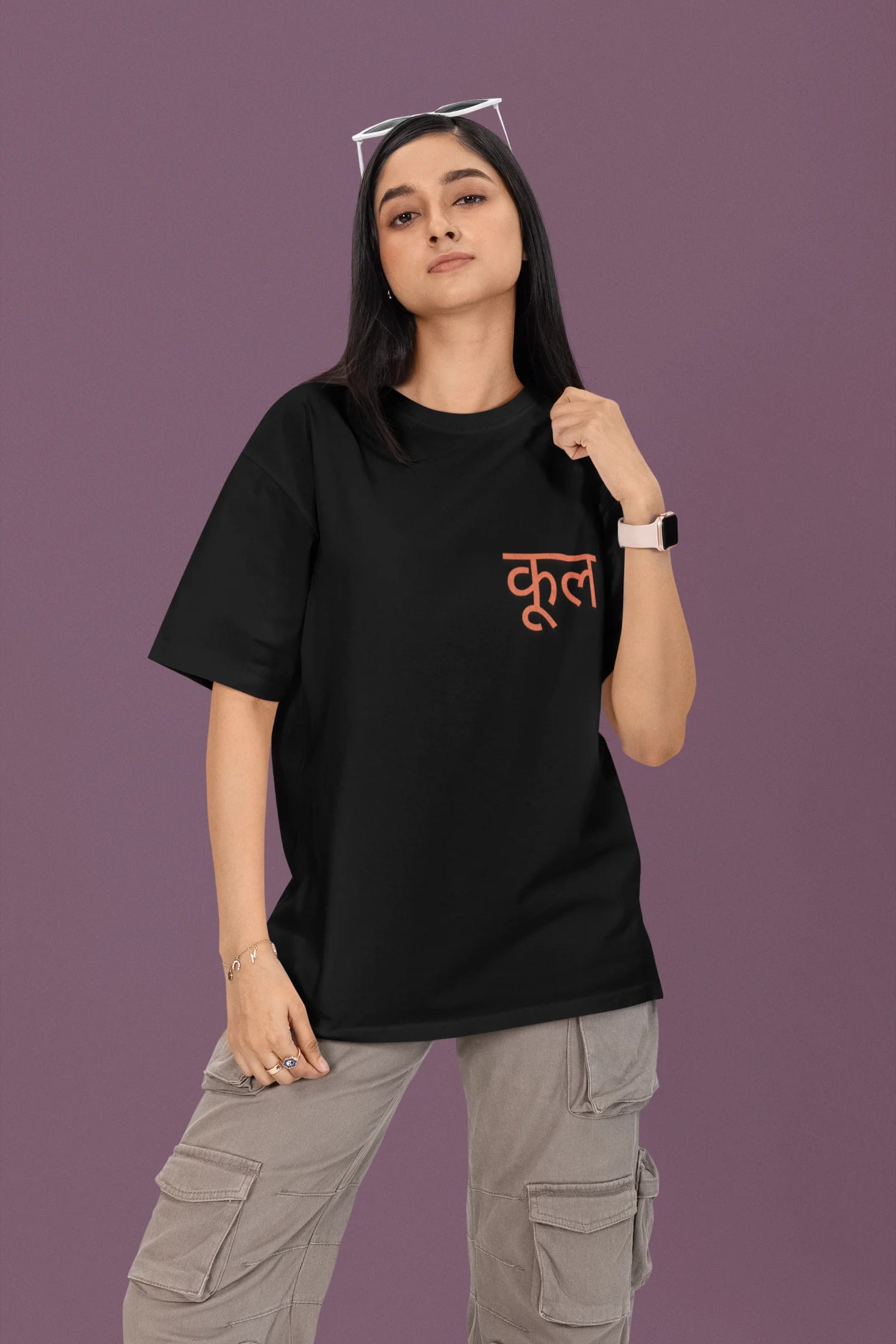First front view of a female model wearing a black oversized t-shirt featuring the Hindi word for "cool" with a unique, playful design.
