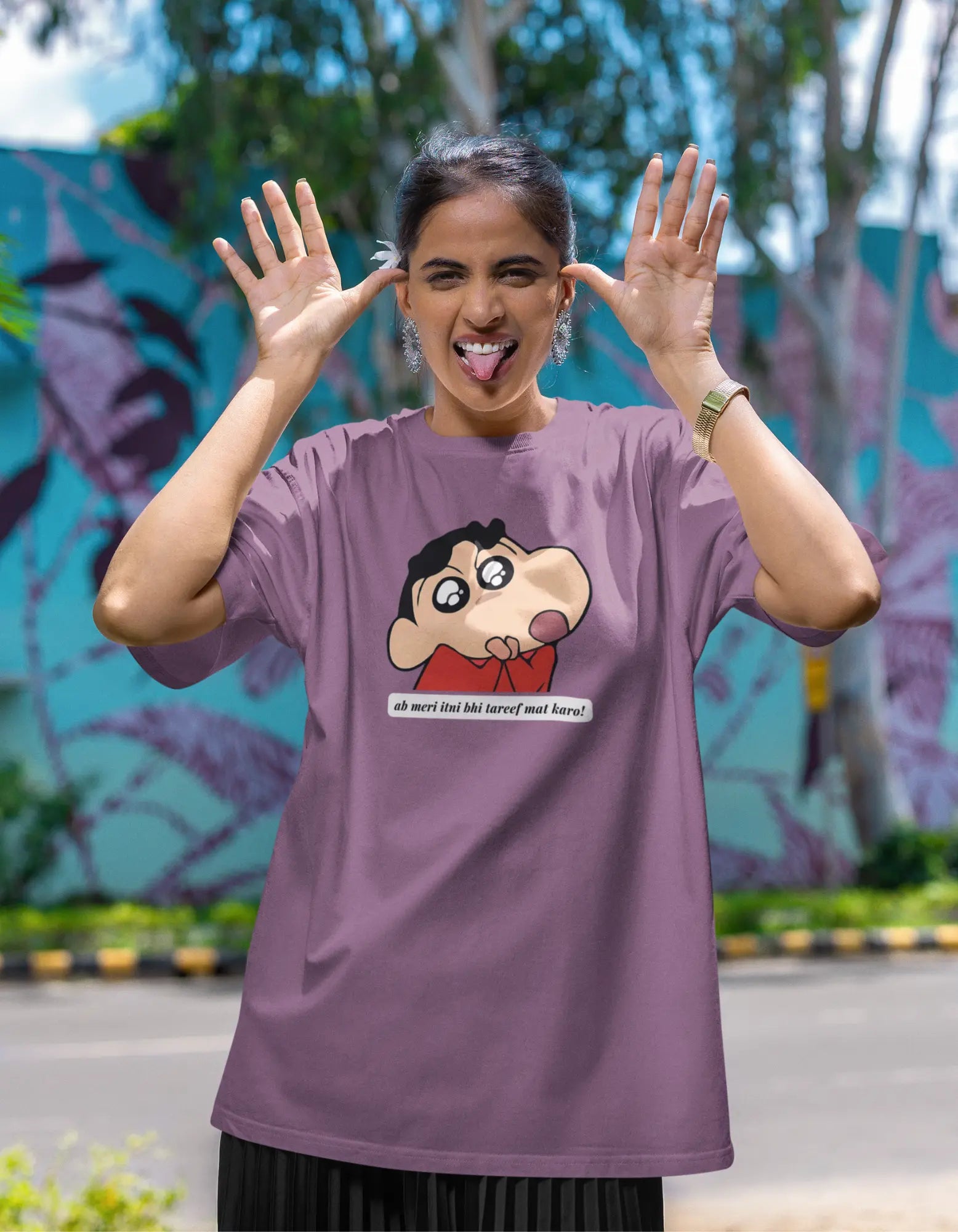 First front view of female model wearing an oversized dirty purple tee featuring Shinchan with the text "Don't Praise Me So Much" in Hindi. A perfect blend of humor and nostalgia for Shinchan fans.