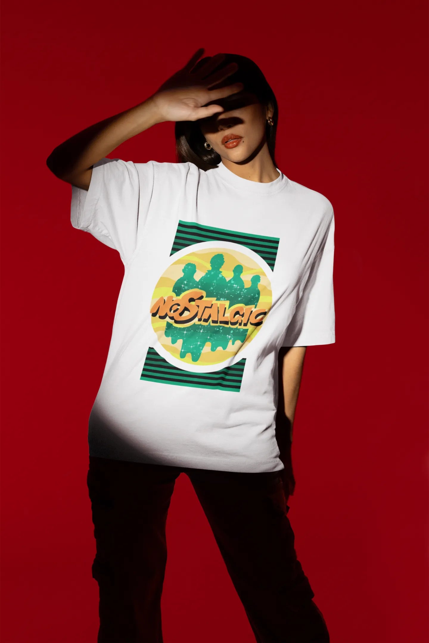 Second view of a female model wearing an oversized off-white t-shirt with a shadow silhouette of the Coldplay band members and the word "Nostalgic" printed on it.