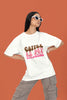 First front view of a female model wearing a white oversized t-shirt with the text 