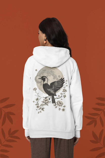 Back view of a female model wearing a white hoodie with a heron taking off under the moonlight.