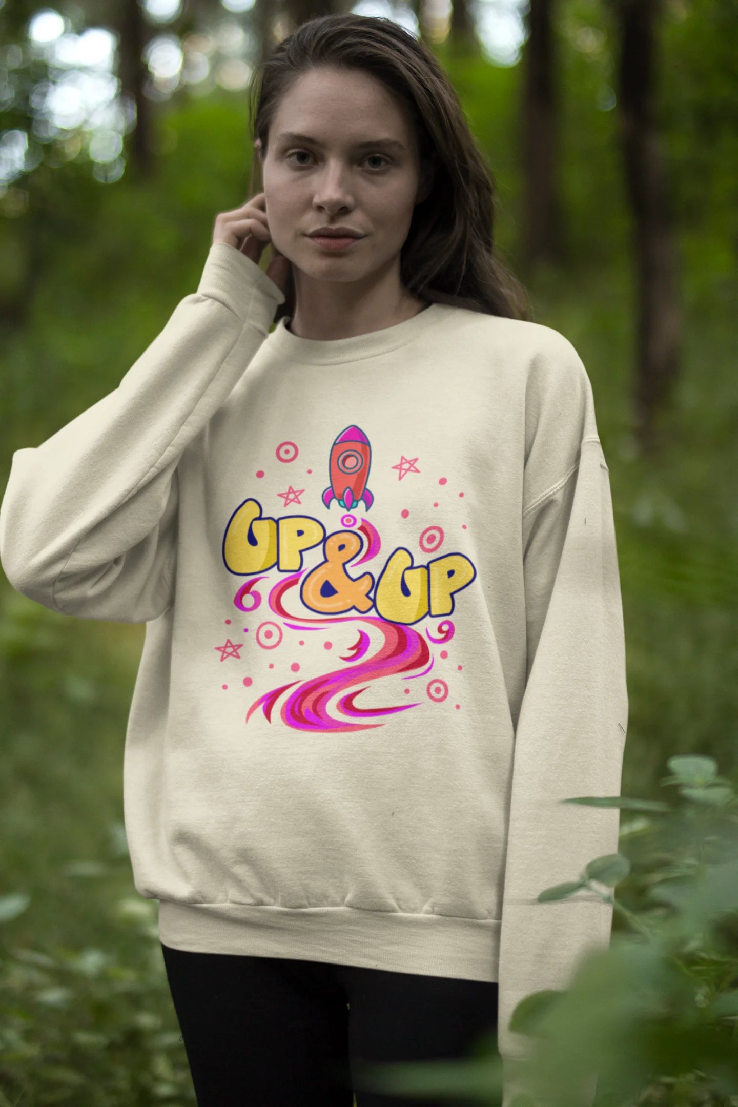 Second front view of a male model wearing an cream sweatshirt with a rocket ship design and the text "Up & Up".
