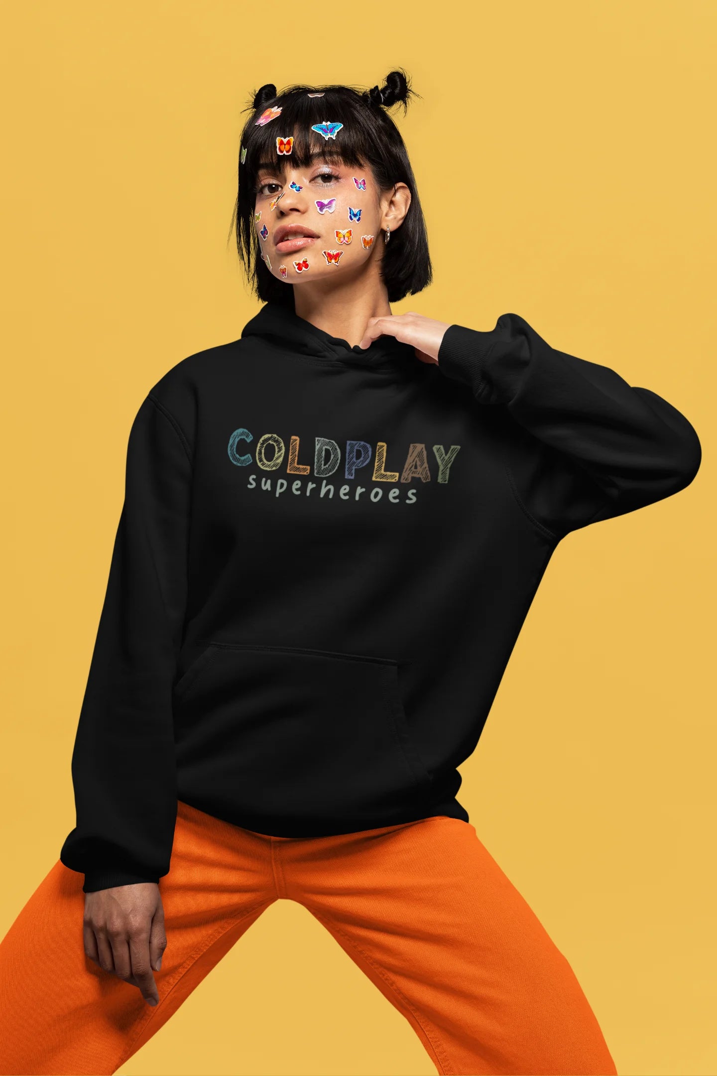 4th front view of a female model wearing an black hoodie with a design inspired by the "Something Just Like This" music video, featuring the word "Superheroes".