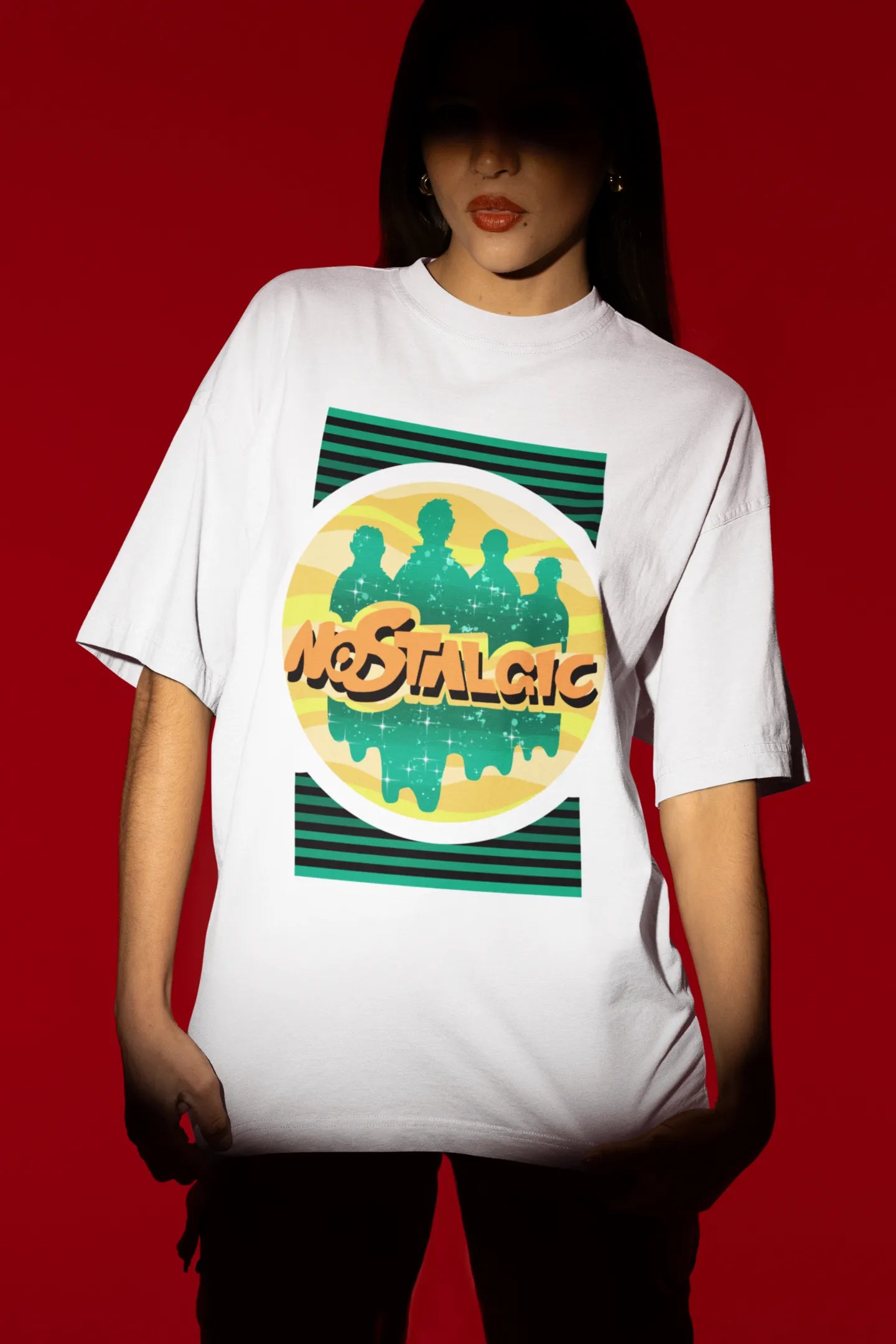 Fourth view of a female model wearing an oversized off-white t-shirt with a shadow silhouette of the Coldplay band members and the word "Nostalgic" printed on it.