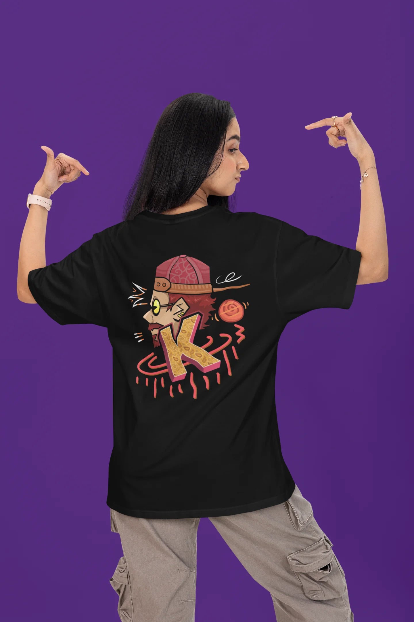 Back view of a female model wearing a black oversized t-shirt featuring the Hindi word for "cool" with a unique, playful design.