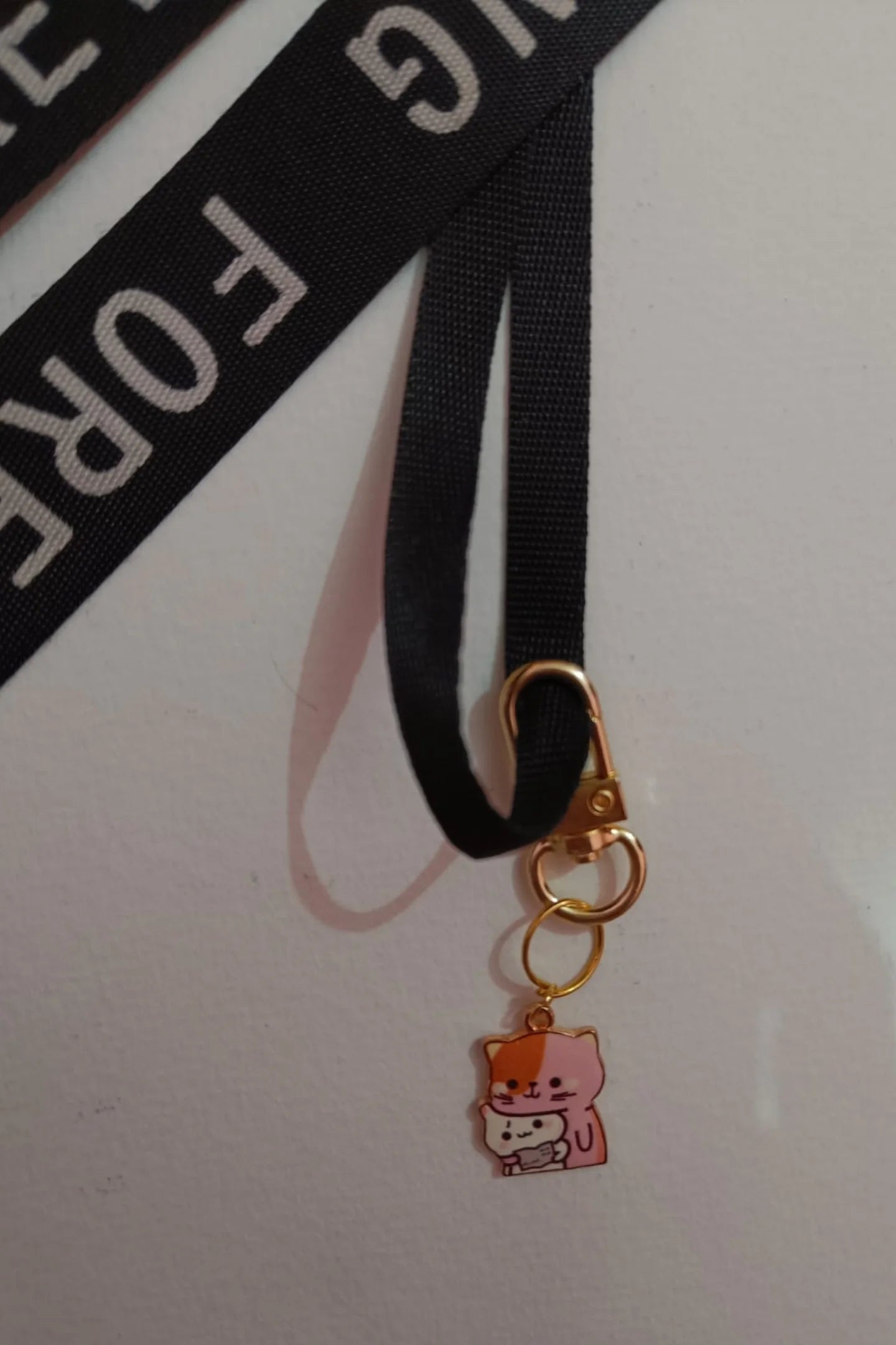 Second view of a keychain featuring a design of a mother cat and her kitten.