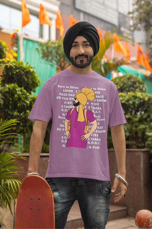 First image of a male model wearing a dirty purple oversized t-shirt with a Diljit Dosanjh portrait on a t-shirt with his album titles written in the background.