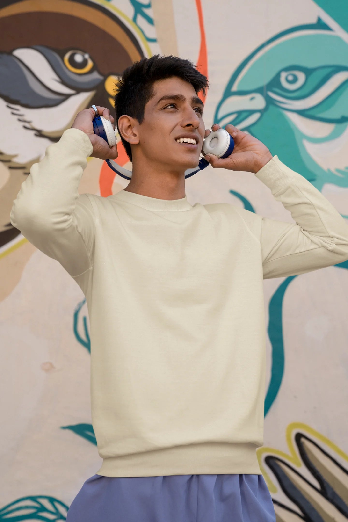 Third front view of a male model wearing a off-cream F.R.I.E.N.D.S. sweatshirt featuring a fun design inspired by Phoebe Buffay and her iconic quotes.