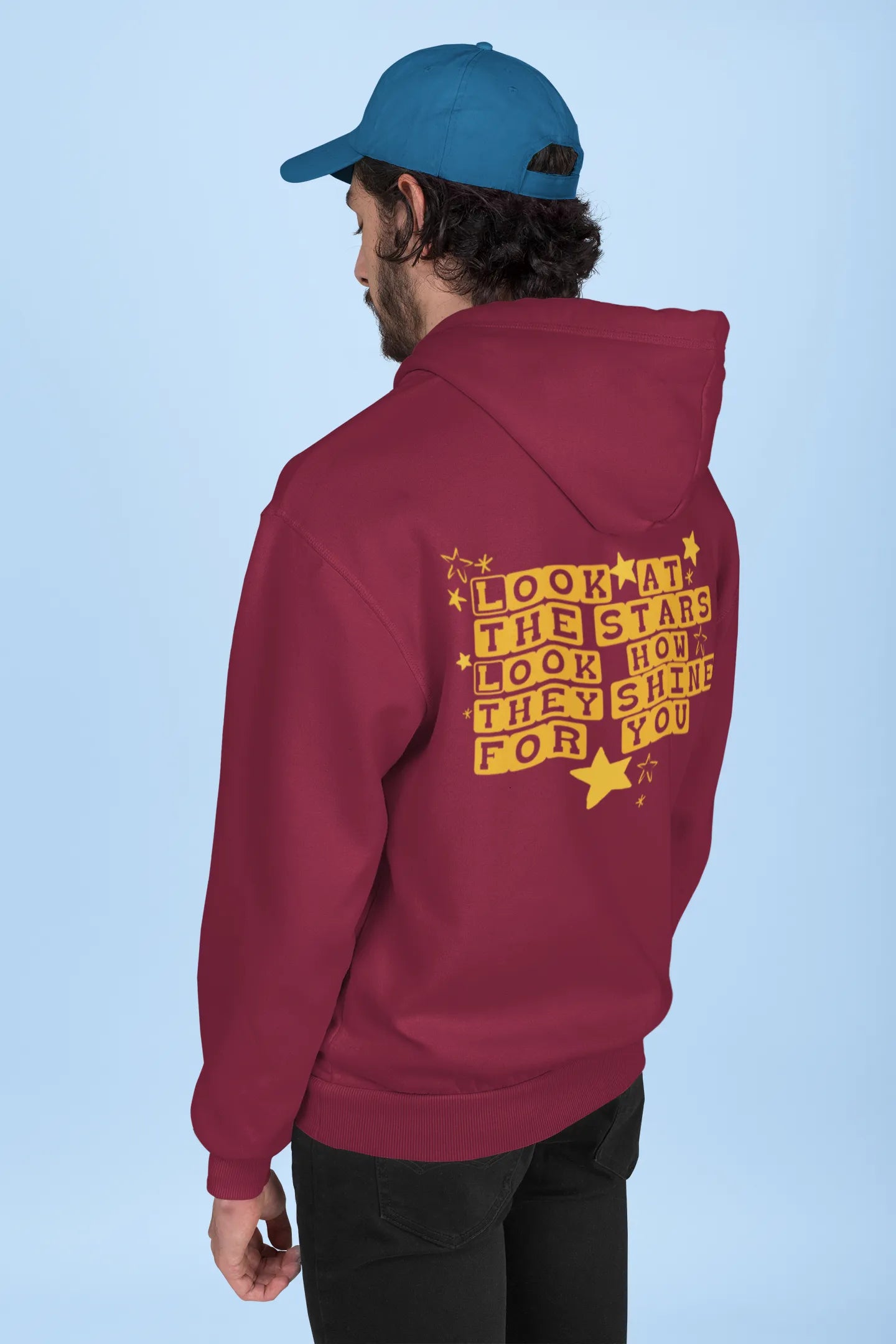 Back view of a male model wearing a maroon hoodie with the "Yellow" album artwork by Coldplay.