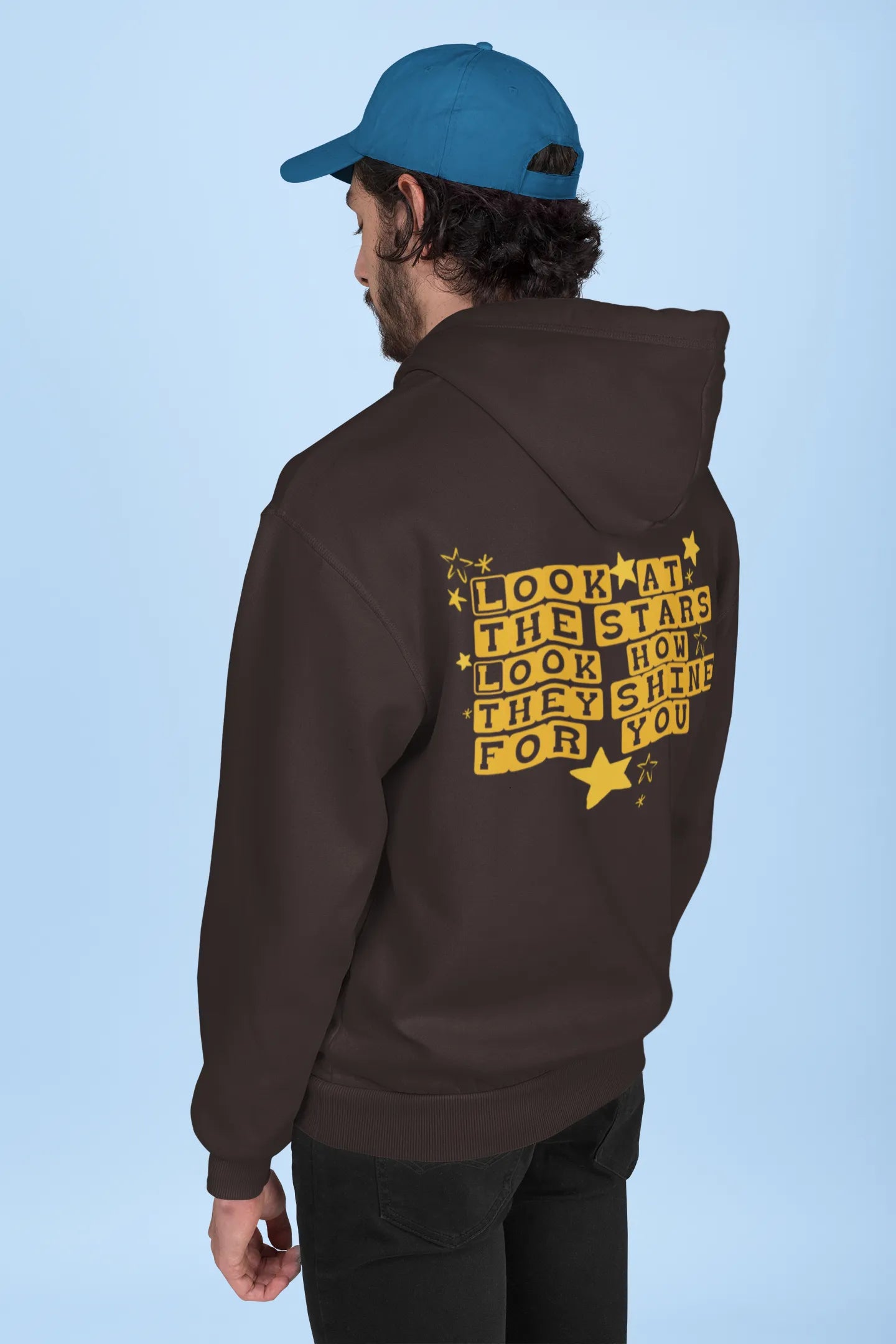 Back view of a male model wearing a chocolate brown hoodie with the "Yellow" album artwork by Coldplay.