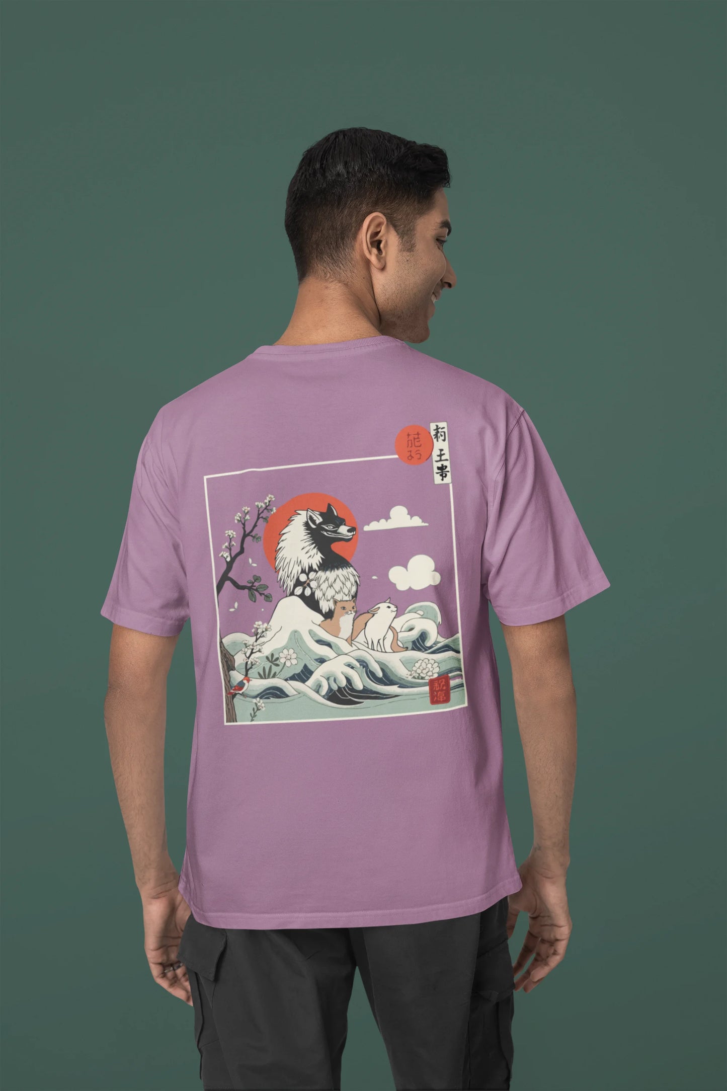 Back view of a male model wearing a dirty purple oversized tee with a design of a wolf surveying a Japanese landscape.