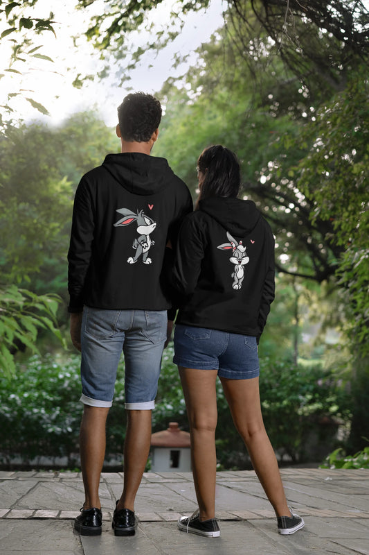 Back view of a couple wearing matching hoodies, one with a Bugs Bunny design and the other with a Lola Bunny design.