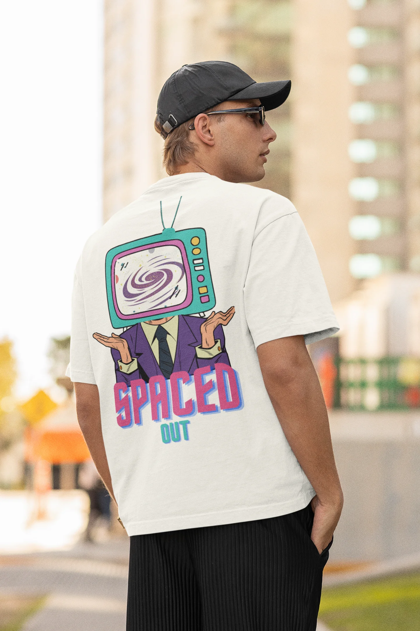 Back view of a male model wearing a white oversized t-shirt with a bold graphic that reads "Need Some Space" on the front. The design incorporates subtle hints of the Milky Way galaxy and the solar system on the back.