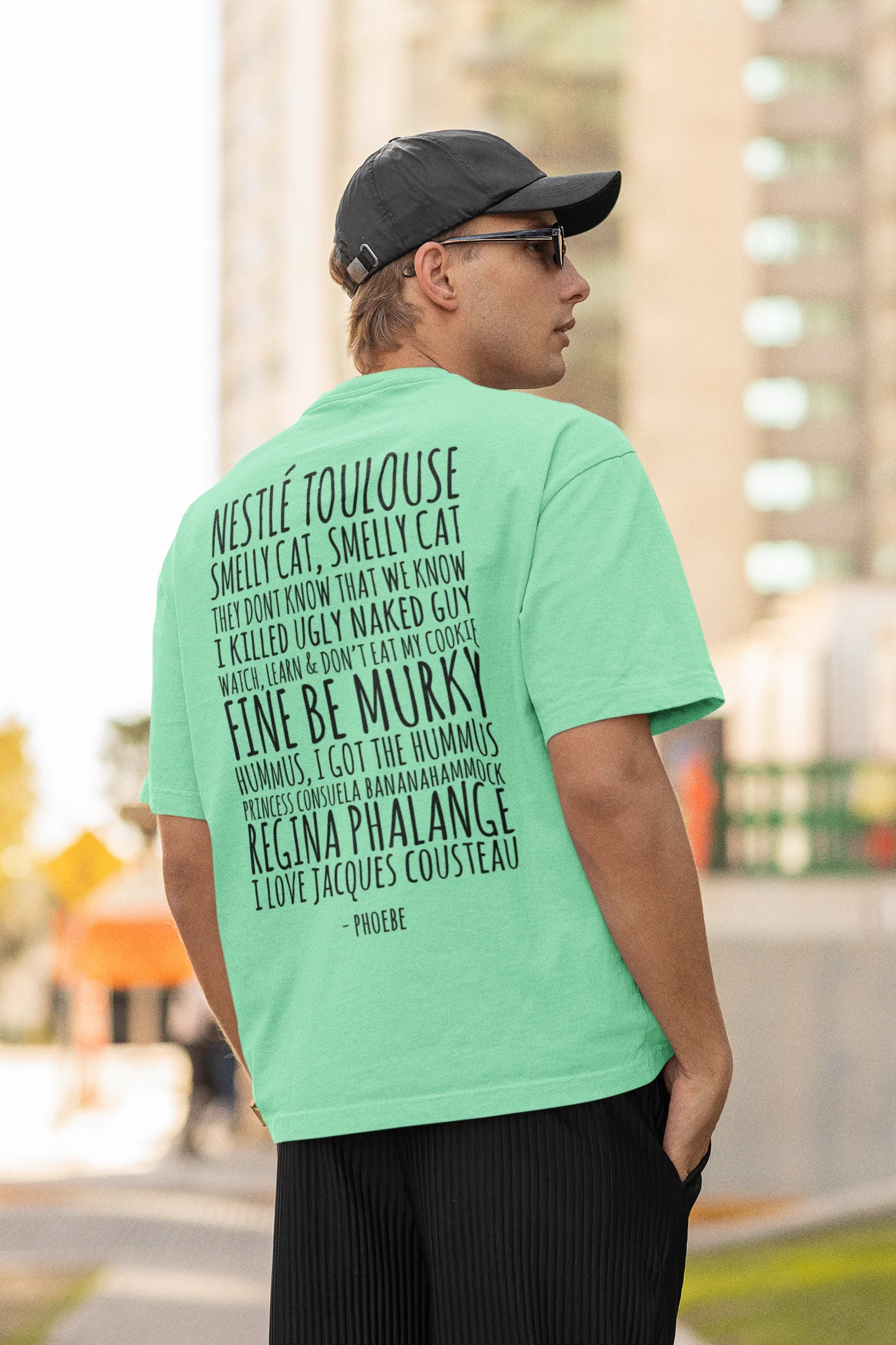 Back view of male model wearing a mint green oversized F.R.I.E.N.D.S. t-shirt featuring a fun design inspired by Phoebe Buffay and her iconic quotes.