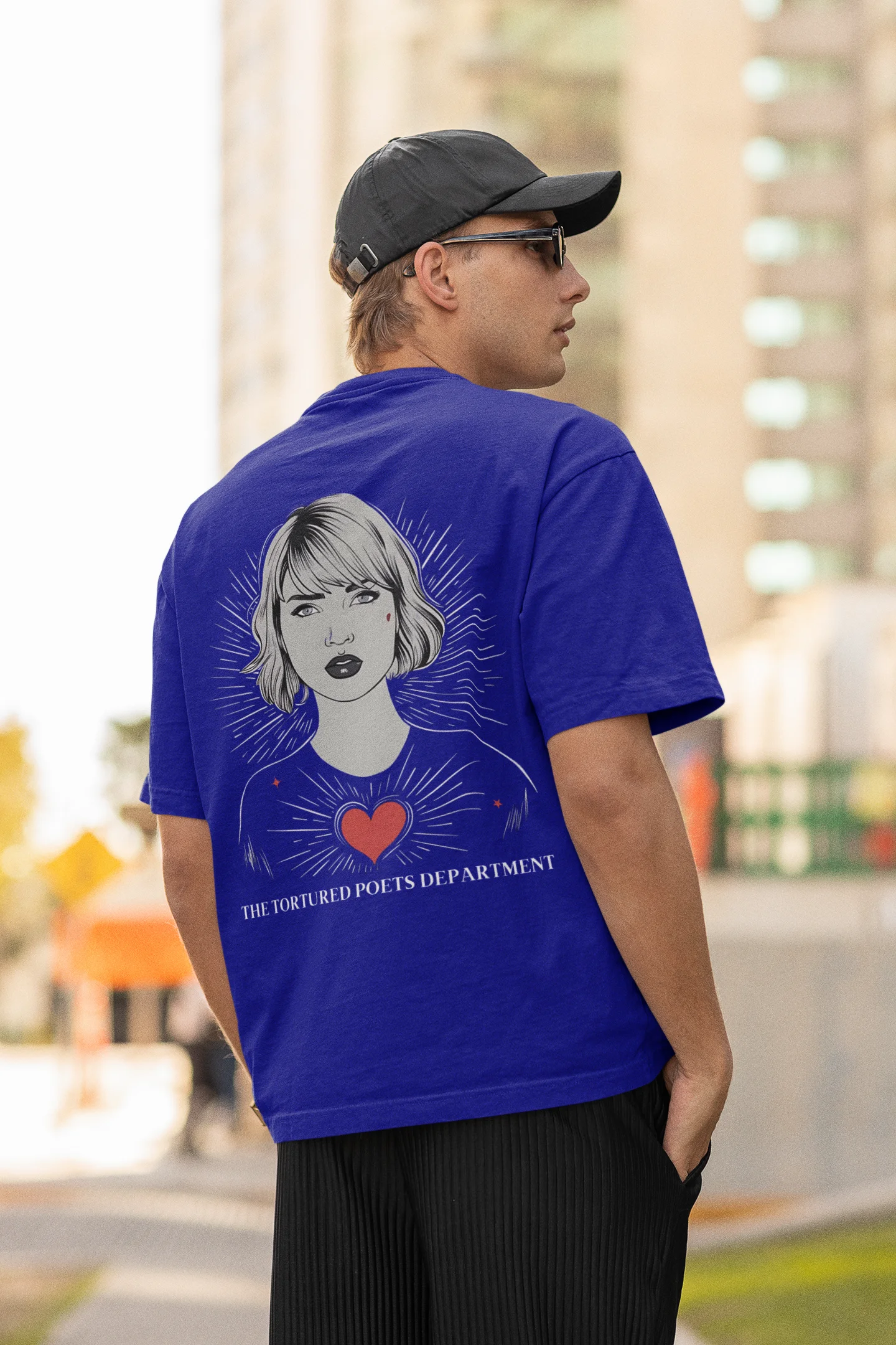 Back view of man wearing blue Oversize Taylor Swift T-Shirt featuring Fortnight Theme.