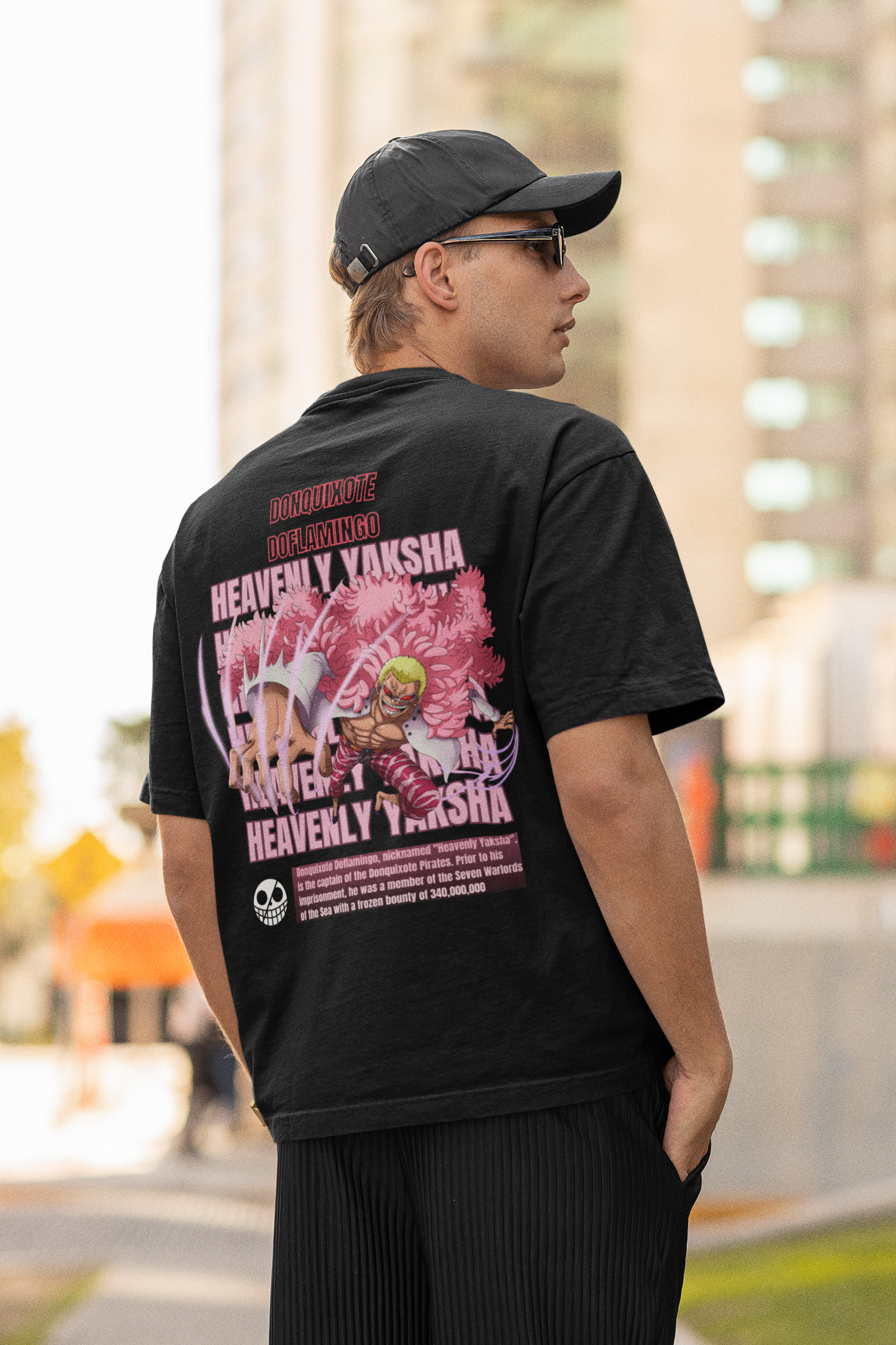 Back view of a male model wearing a black oversized t-shirt featuring Donquixote Doflamingo from the One Piece anime.