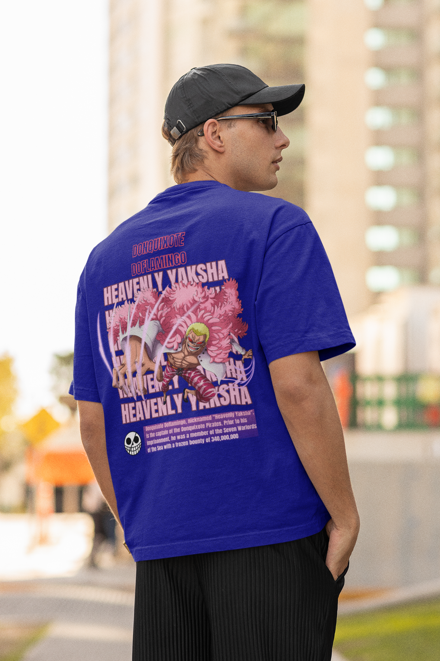 Back view of a male model wearing a royal blue oversized t-shirt featuring Donquixote Doflamingo from the One Piece anime.