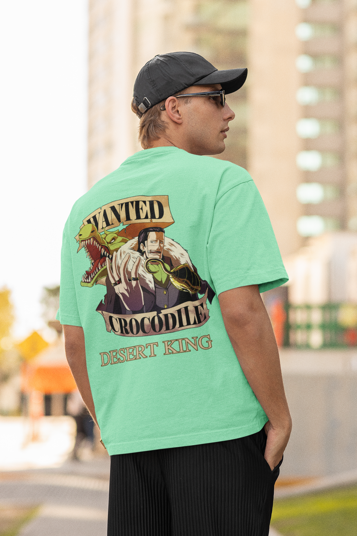 Back view of a male model wearing a mint green oversized t-shirt featuring Crocodile, the Desiccation Master, from the One Piece anime.