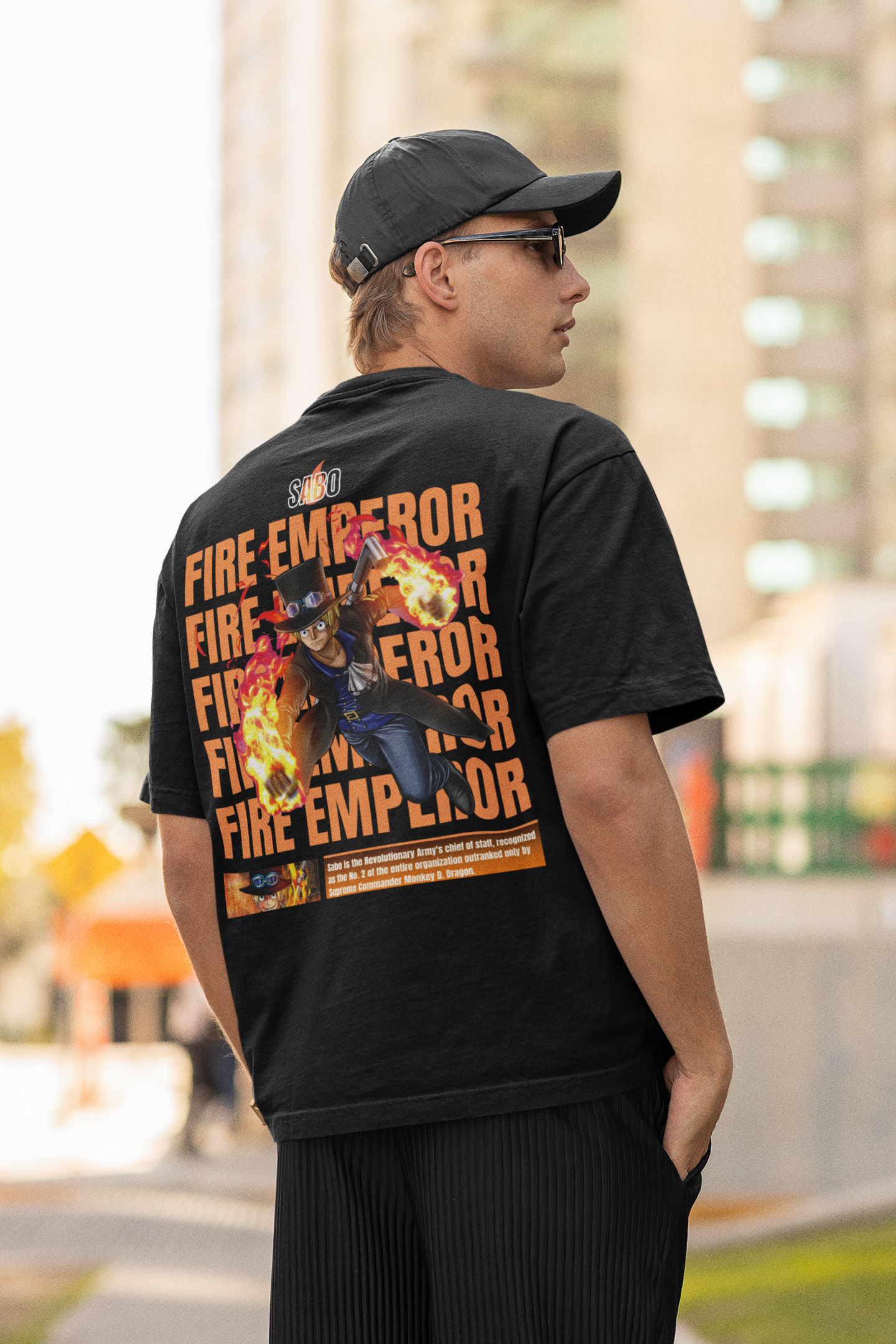 Back view of a male model wearing a black oversized t-shirt featuring Sabo with the text "Flame Emperor."