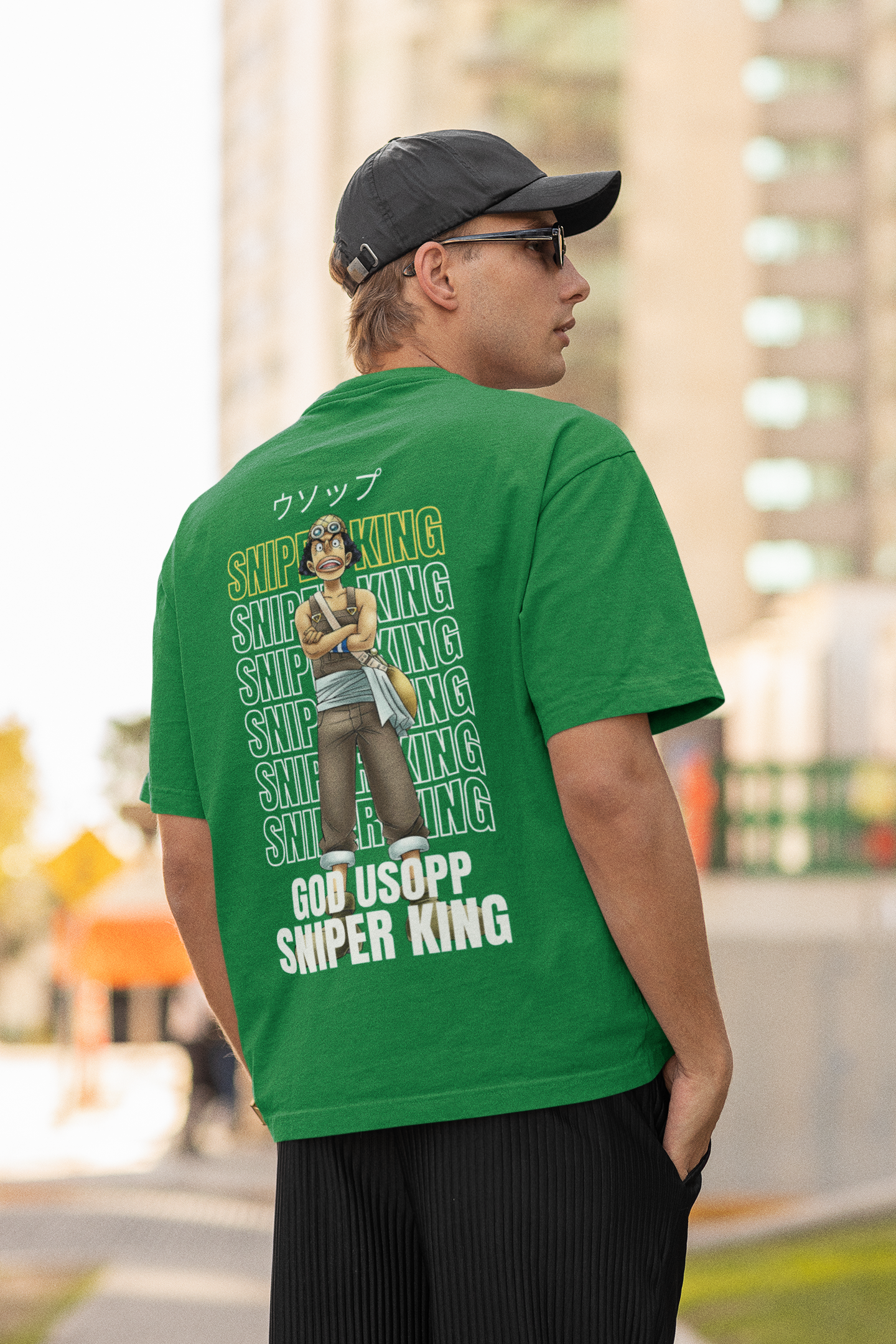 Back view of a male model wearing a forest green oversized t-shirt featuring Usopp from the One Piece anime.