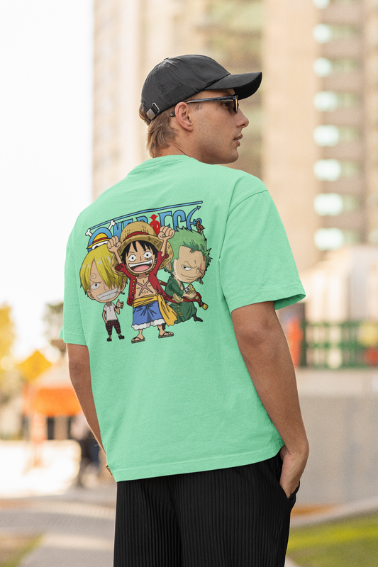 Back view of a male model wearing a mint green oversized t-shirt featuring chibi versions of the main characters from the One Piece anime.